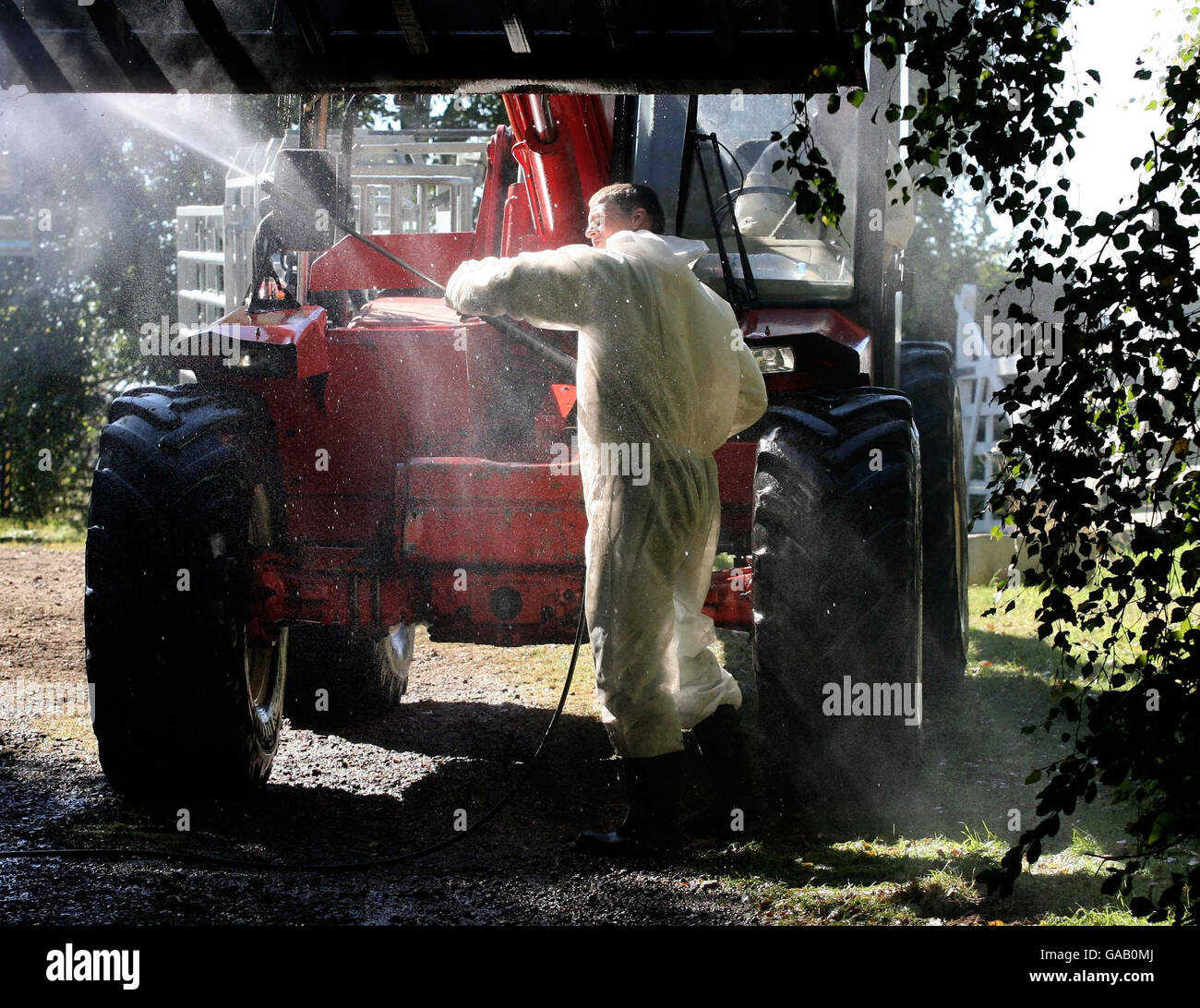 Gli imprenditori agricoli puliscono i veicoli agricoli in una fattoria conosciuta localmente come il Klondike, vicino a Egham, Surrey, dopo che le pecore sospettate di avere piede e bocca sono state abbattute ieri notte. Foto Stock