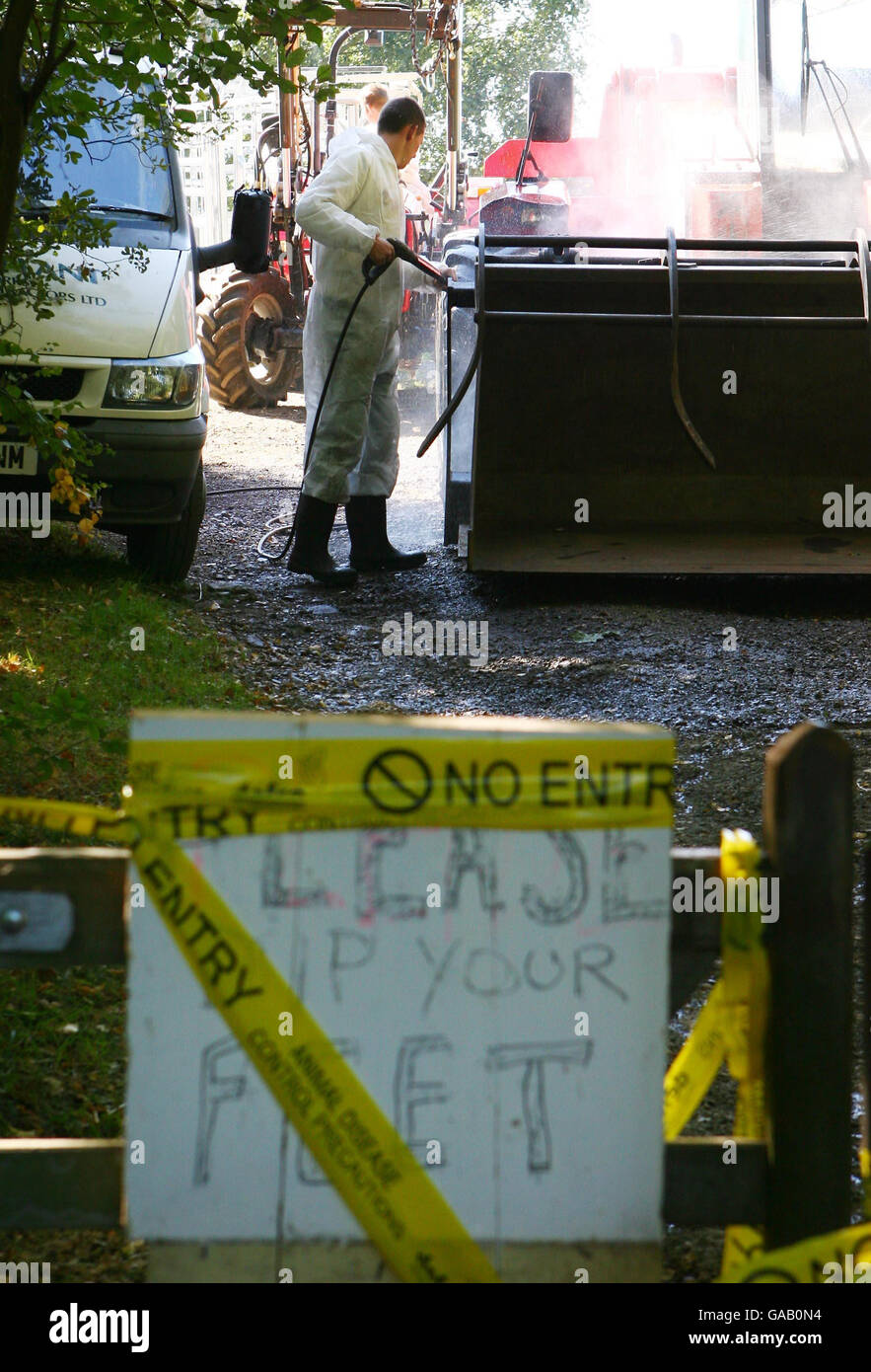 Gli imprenditori agricoli puliscono i veicoli agricoli in una fattoria conosciuta localmente come il Klondike, vicino a Egham, Surrey, dopo che le pecore sospettate di avere piede e bocca sono state abbattute ieri notte. Foto Stock