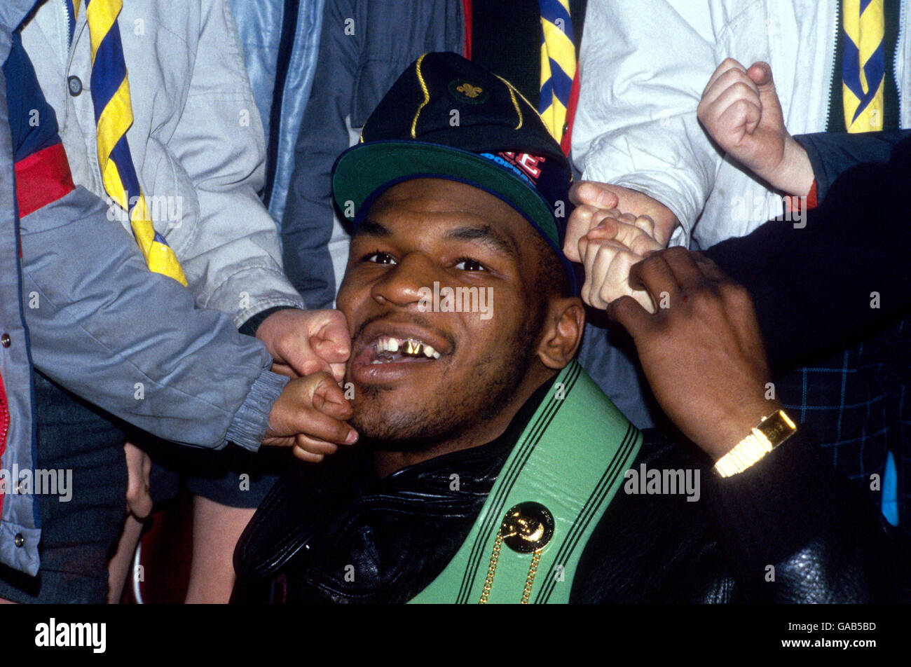 Mike Tyson, campione mondiale di pesi massimi, è sommerso da una diga di pugni da una troupe scout locale Foto Stock