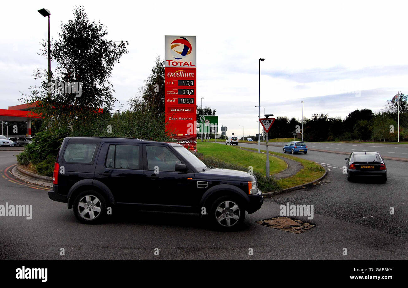 Vista generale dei veicoli che lasciano una stazione di servizio nel Derbyshire meridionale. Il nuovo prezzo del carburante viene visualizzato con il carburante diesel a 1 litro e il carburante senza piombo a 99.2 pence al litro. Foto Stock