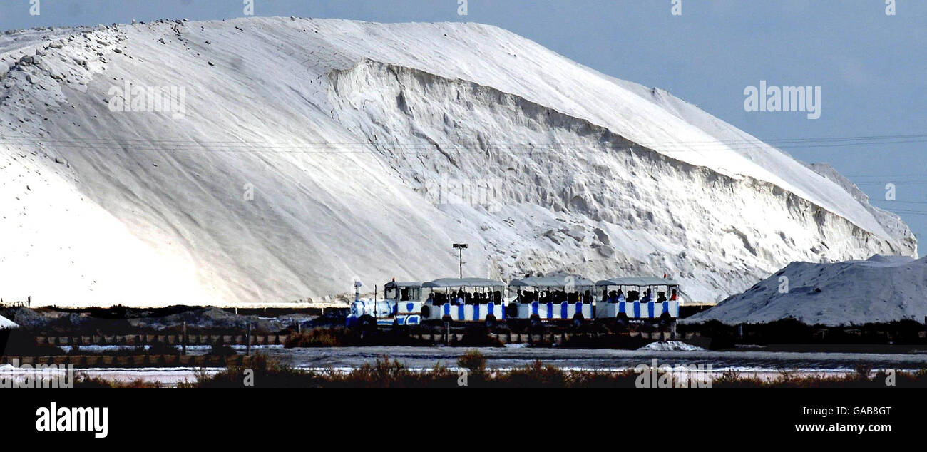 Un treno porta i visitatori davanti a una montagna di sale nell'antica paludosa del sale intorno ad Aigues Mortes in Francia. Foto Stock