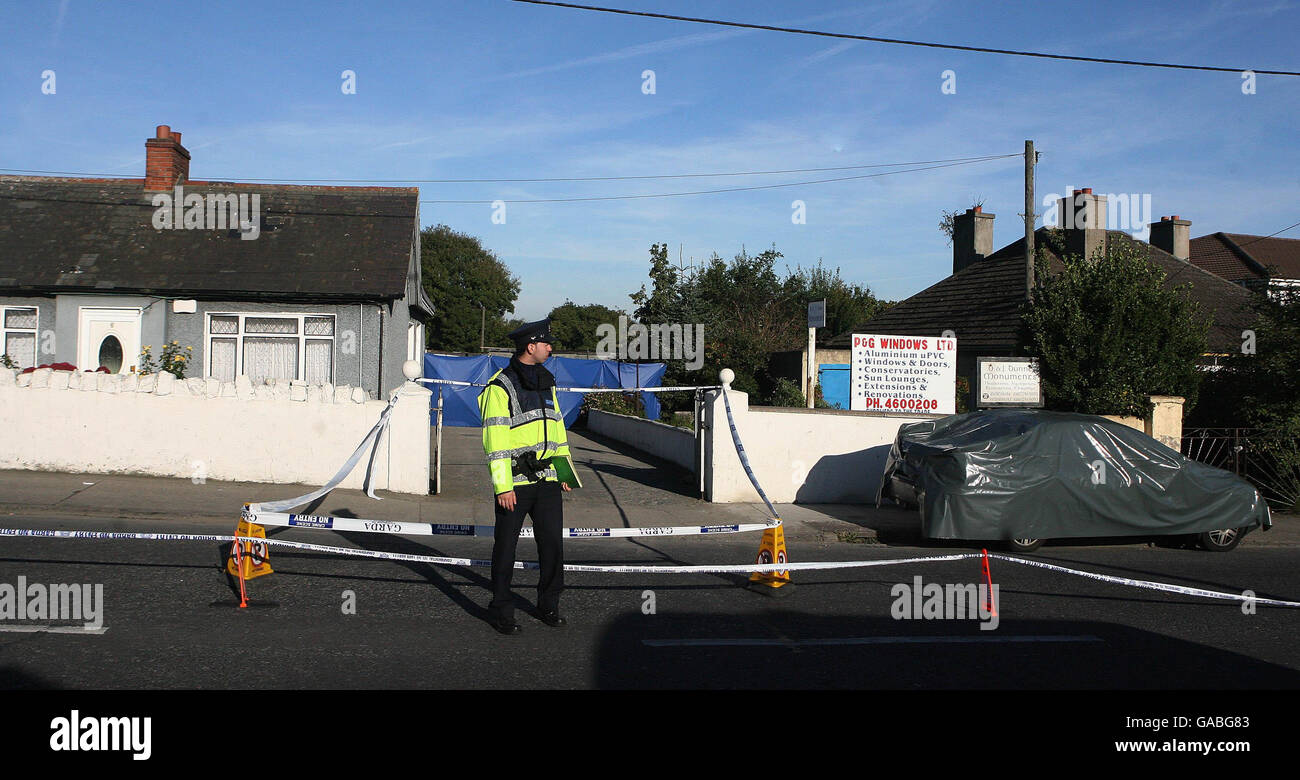 Gli ufficiali di Gardai frequentano la scena di un doppio omicidio in un garage nella zona di Greenhills Road di Walkinstown, a ovest di Dublino. Foto Stock