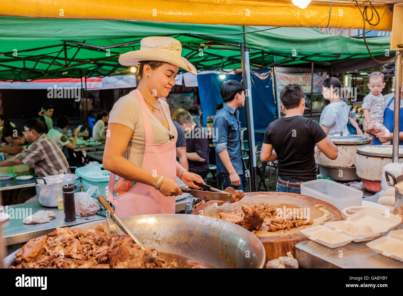 Lady Chef con il cappello da cowboy holding cleaver,Thai street food stallo in Chiang Mai Thailandia Foto Stock
