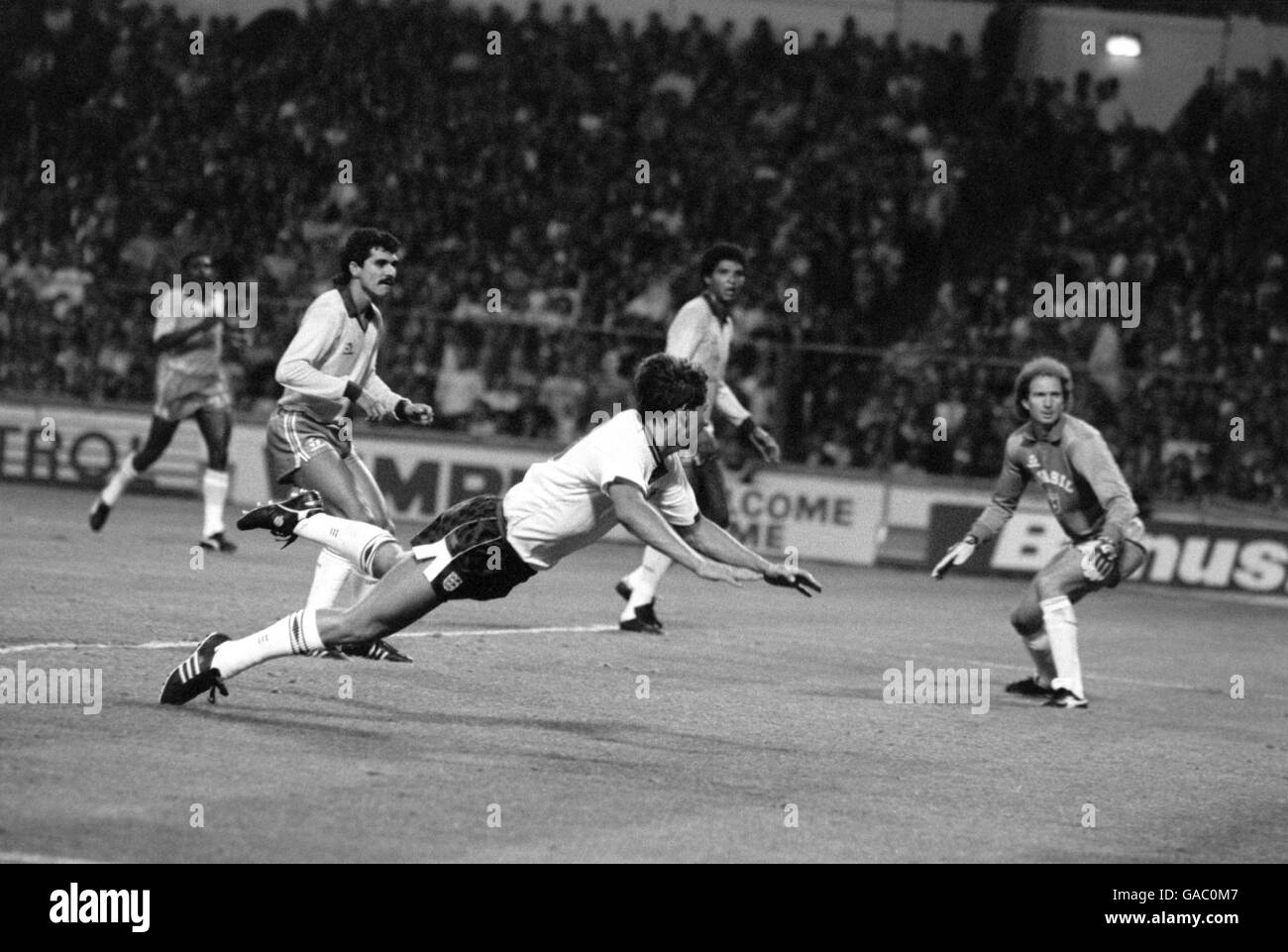 (L-R) l'inglese Gary Lineker si tuffa per far passare la palla Il portiere brasiliano Carlos per l'obiettivo dell'Inghilterra Foto Stock