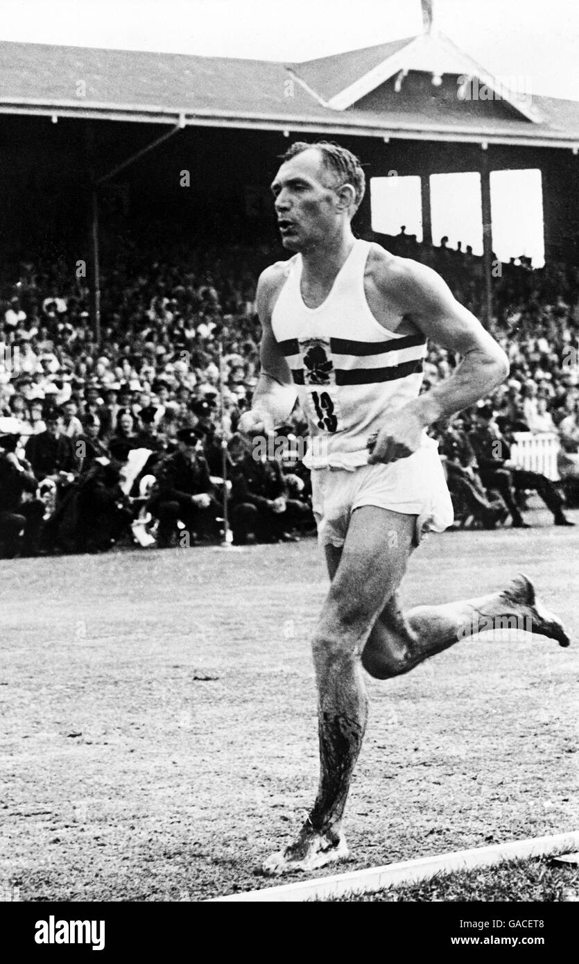 Atletica - 4° British Empire Games - Auckland - Marathon. Il Jack Holden dell'Inghilterra, che ha corso le ultime 16 miglia a piedi nudi su strade accidentate dopo che i suoi picchi sono caduti, viene a casa per vincere l'oro Foto Stock