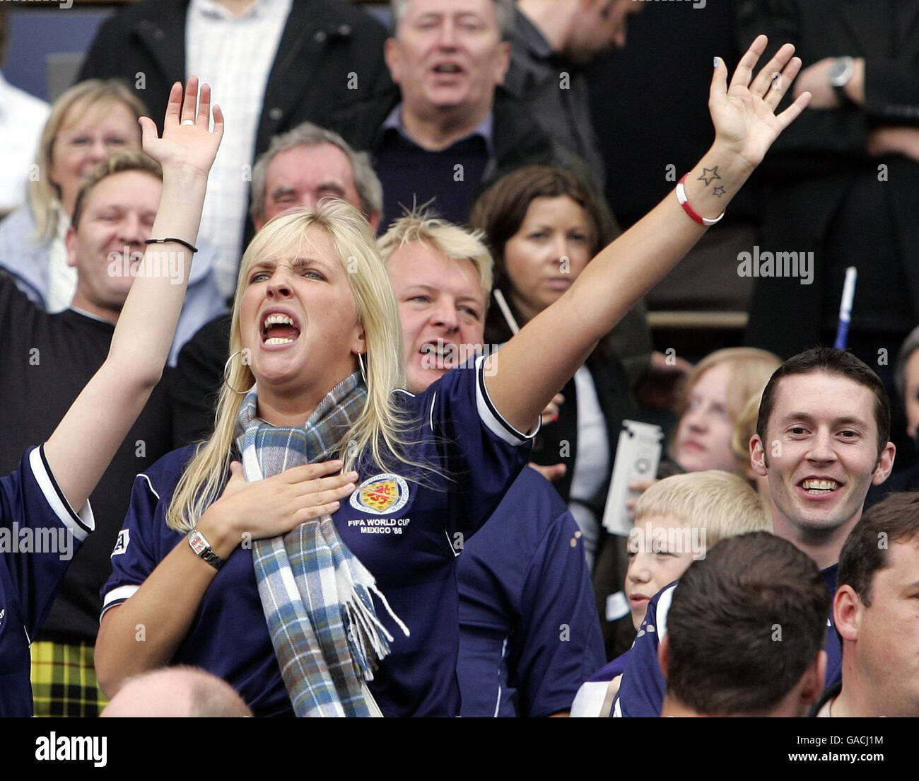 I fan scozzesi vengono registrati a metà tempo cantando l'inno di Runrig Loch Lomond per i bambini in attesa durante la partita di qualificazione del Campionato europeo UEFA a Hampden Park, Glasgow. Foto Stock