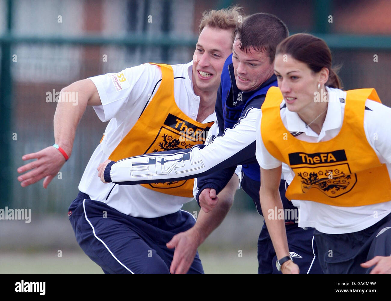 Il principe William della Gran Bretagna, partito, corre contro altri due durante una sessione di addestramento di calcio mentre visita il progetto Hat-Trick dell'associazione di calcio al università della Comunità del cancello occidentale, centro per lo sport, a Newcastle, Inghilterra, giovedì. Foto Stock