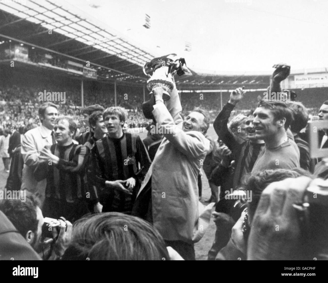 Joe Mercer (c), direttore della città di Manchester, circondato dalla sua squadra trionfante, mostra la fa Cup ai tifosi durante il giro d'onore Foto Stock