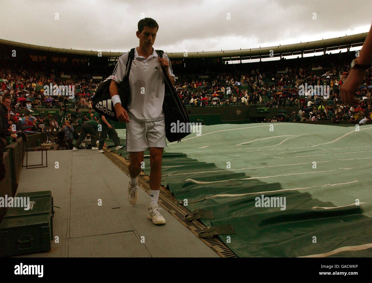 Tennis, Wimbledon 2002, quarto round. Tim Henman esce dal campo mentre i ritardi della pioggia giocano. Foto Stock