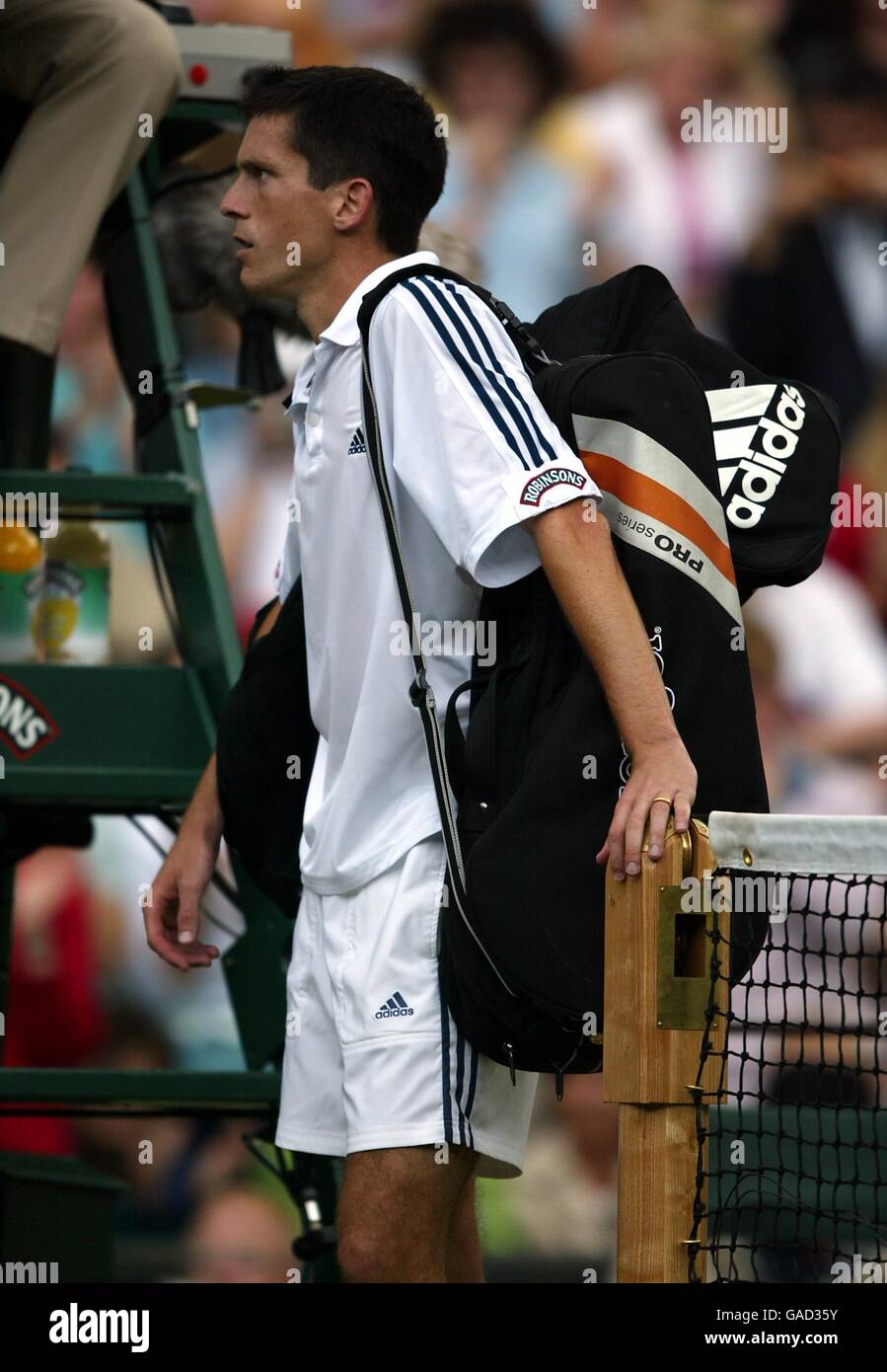 Un Tim Henman deposto si appoggia sul palo netto come Aspetta di camminare dopo aver perso contro Lleyton Hewitt Foto Stock