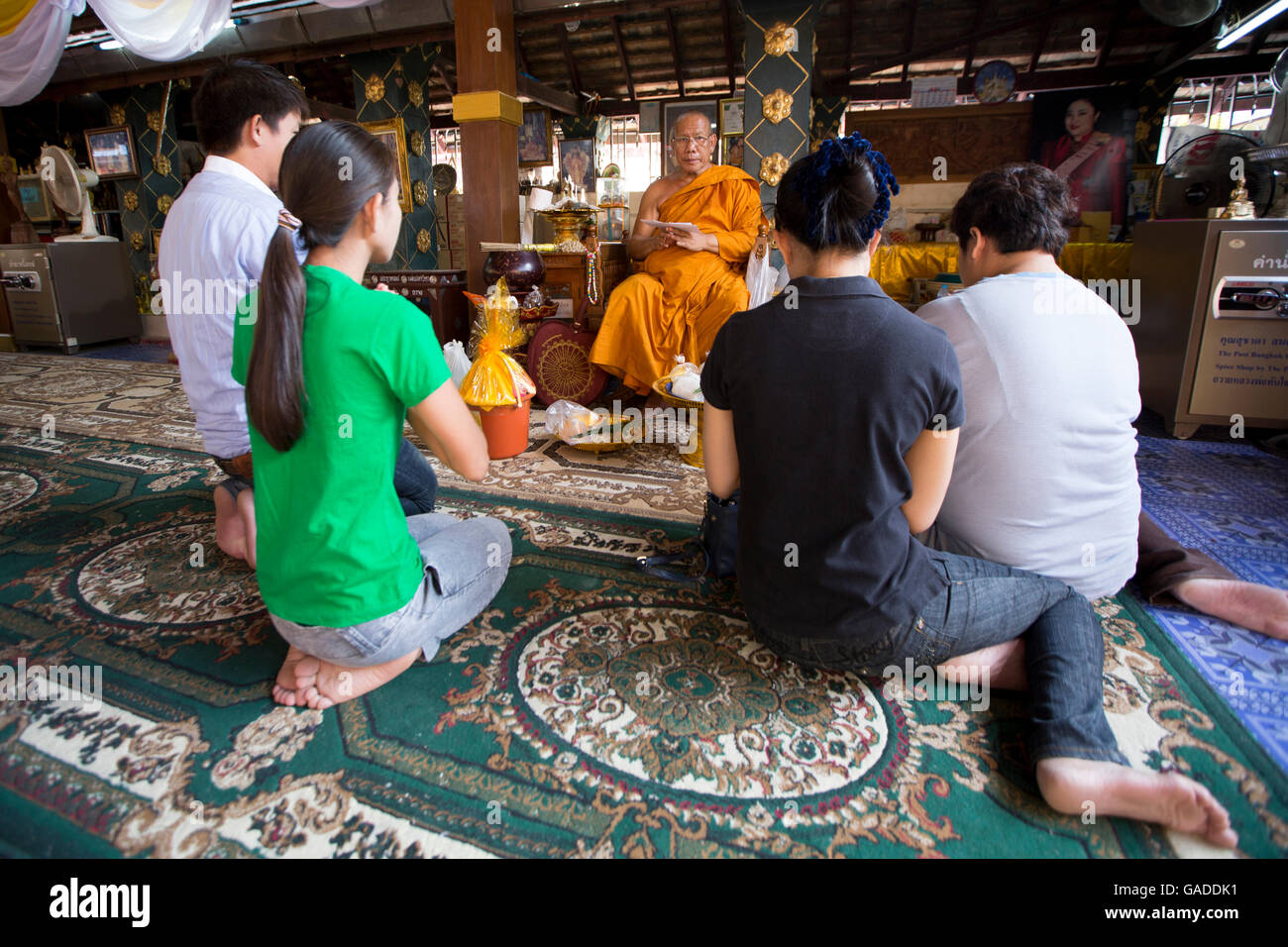 Asia, Thailandia, Chiang mai, Wat Doi Kham (Tempio d'oro), monaco che benedice i voyer del tempio, i voyer del tempio che rendono merito / rispetto pagante, vita di famiglia tailandese Foto Stock