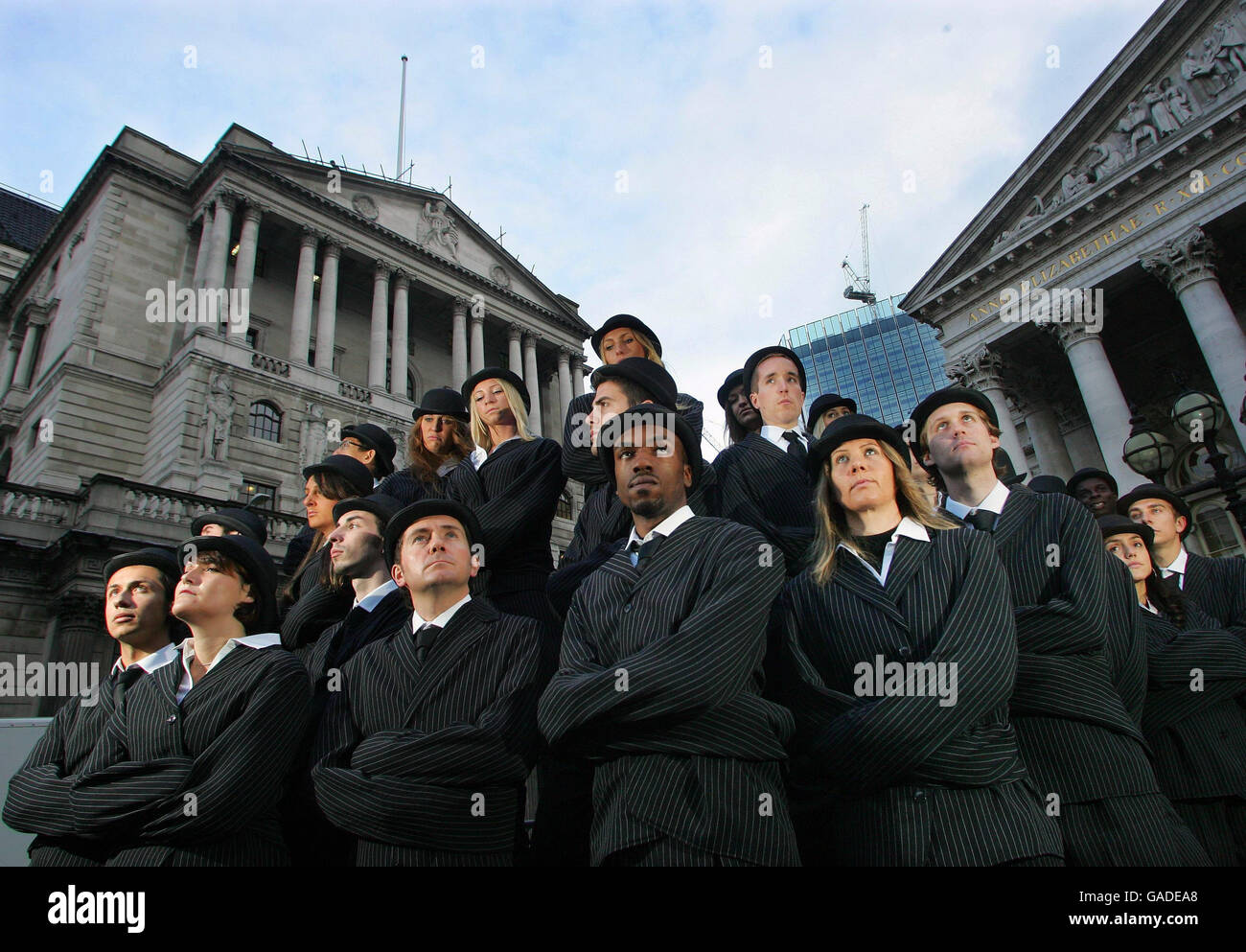 Trenta performer vestiti da uomini d'affari e donne londinesi in giubbotti di paglia, si trovano fuori dalla Bank of England, nella City di Londra, per lanciare una campagna in Cornovaglia per attrarre imprese da ricollocare nella contea e lontano dalle catene di Londra. Foto Stock