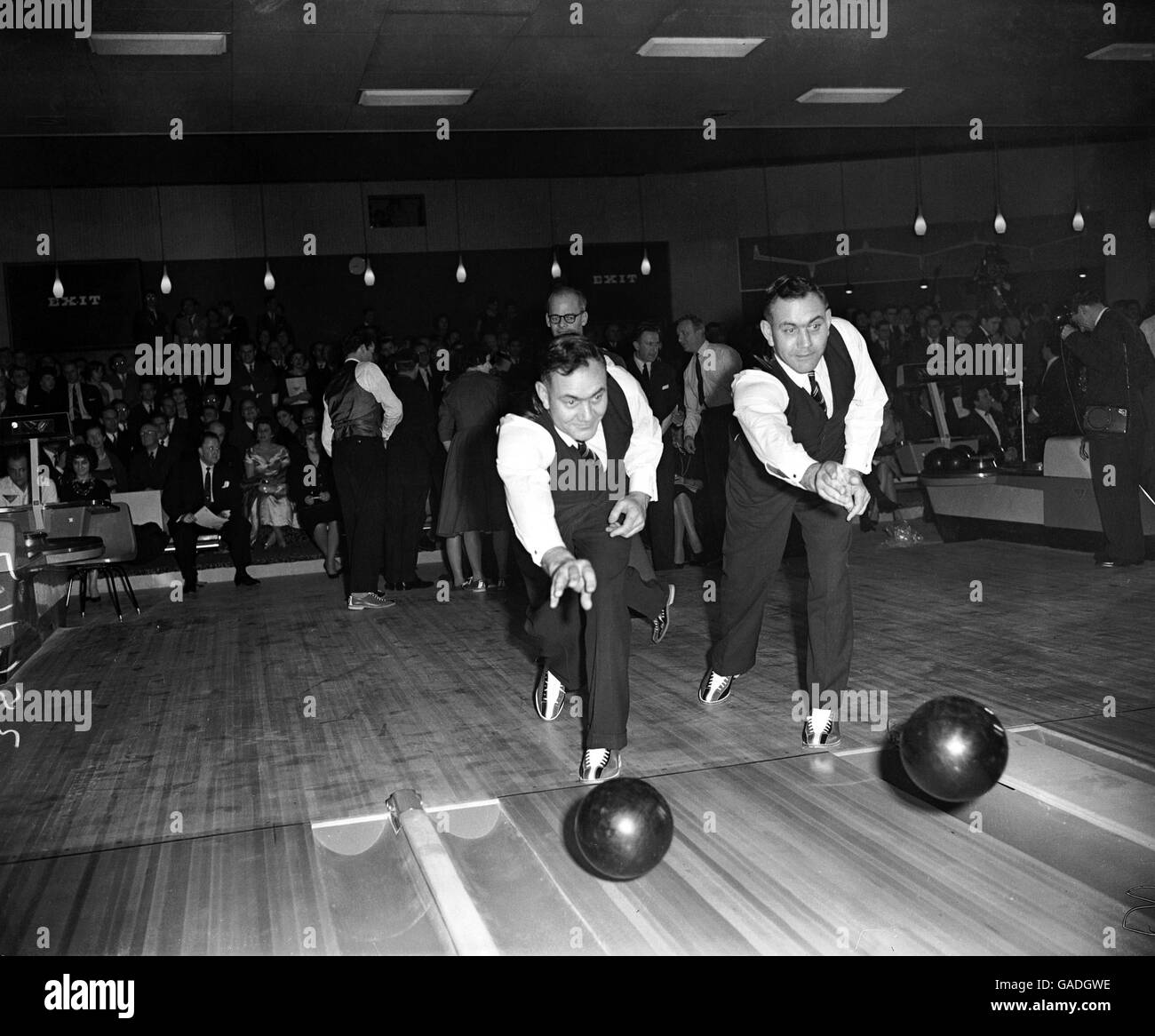 (L-R) i due gemelli bedser, Eric e Alec, provano la loro mano ad un tipo differente di bowling Foto Stock