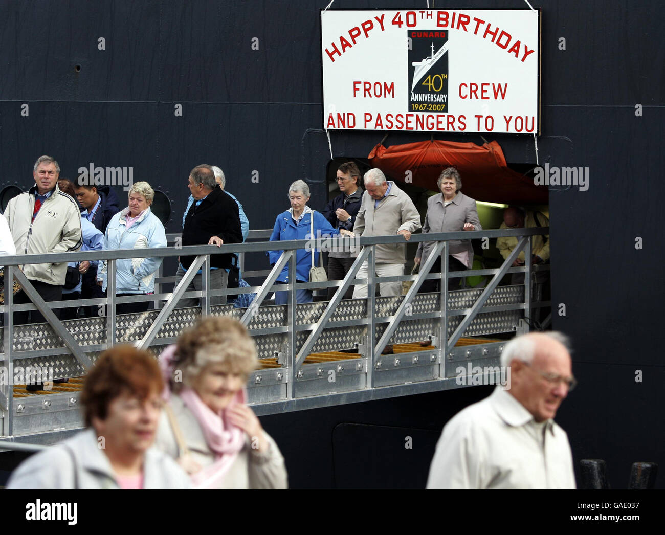 I passeggeri sbarcano dalla QE2 dopo essere arrivati all'Ocean Terminal sul Firth of Clyde questa mattina presto. Foto Stock