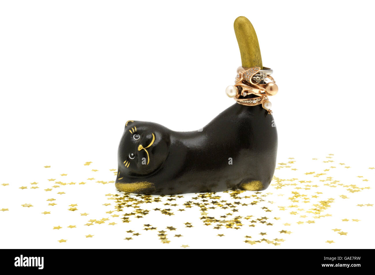 Statuetta di un gatto con ornamenti d'oro sulla coda. Isolato su sfondo bianco. Foto Stock