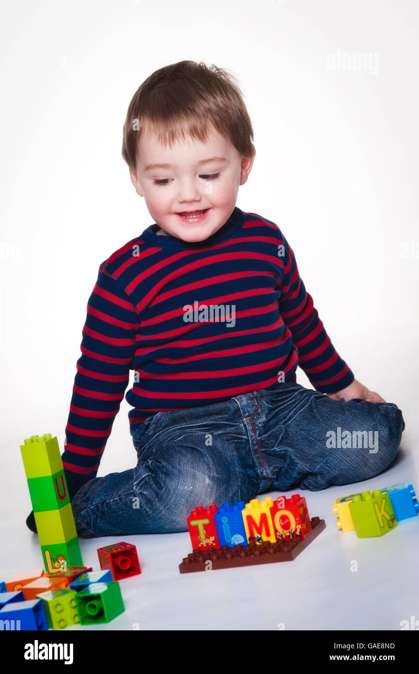 Il ragazzo, due anni, con mattoni giocattolo Foto Stock