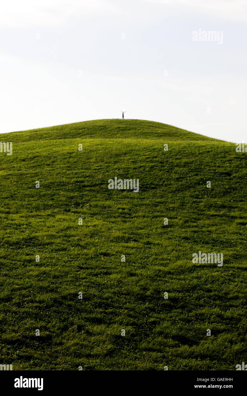 La donna sventola sulla cima di una collina Foto Stock
