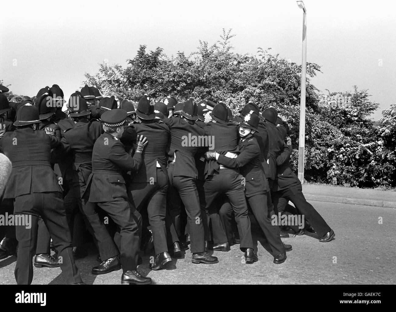 Una linea di polizia tiene indietro i sottaceti dei minatori agli scontri odierni alla pianta di coking di Orgreave vicino Rotherham. Foto Stock