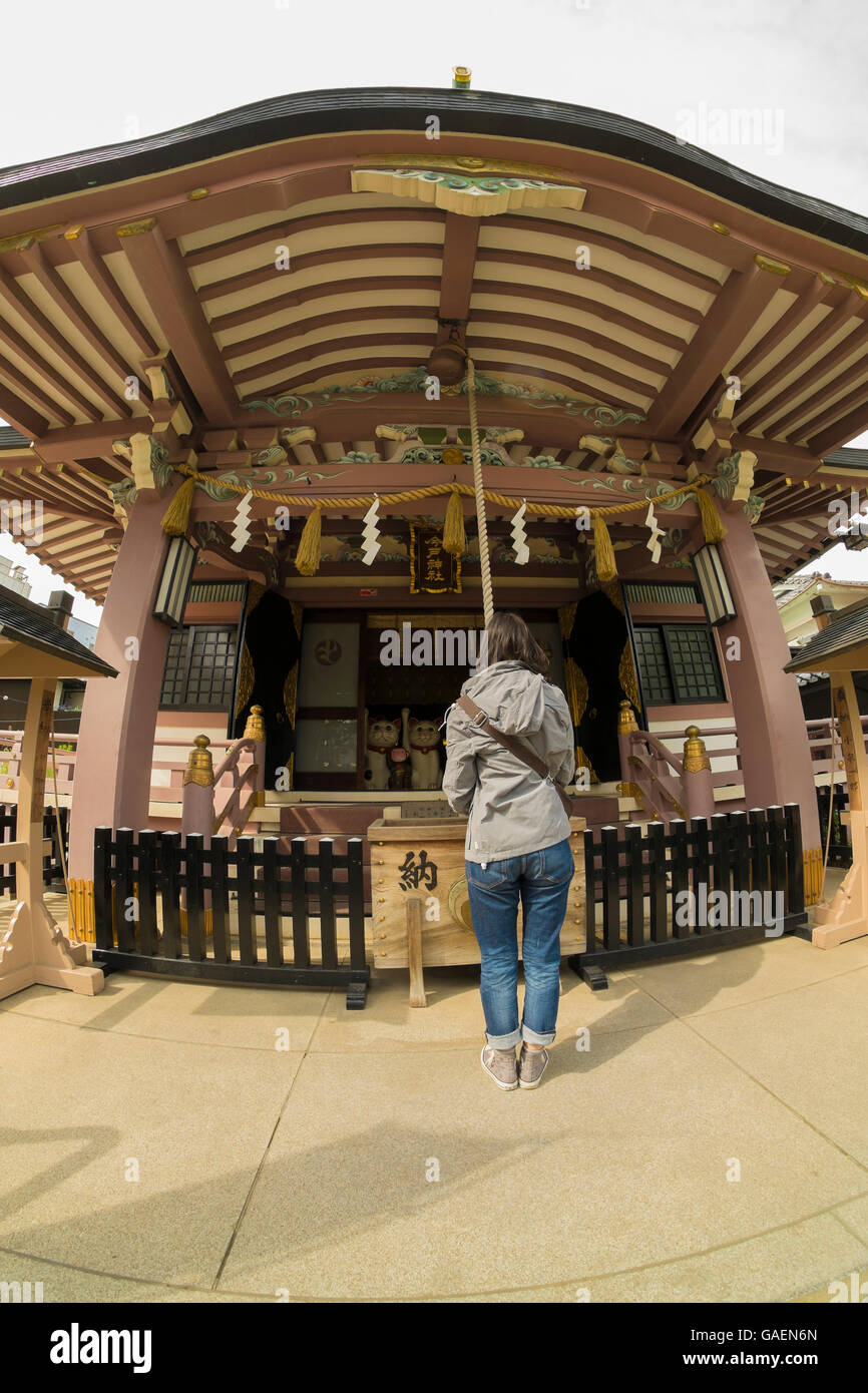 Una donna giapponese pregare presso un santuario buddista in Giappone Foto Stock