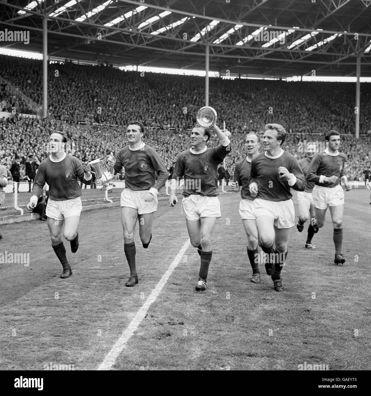 Manchester United (l-r) Maurice Setters, Noel Cantwell, Pat 'Paddy' Crerand, Bobby Charlton, Albert Quixall, David Gaskell (portiere), John Giles fa il giro d'onore dopo che il Manchester United aveva battuto Leicester City 3-1 nella finale della fa Cup. Foto Stock
