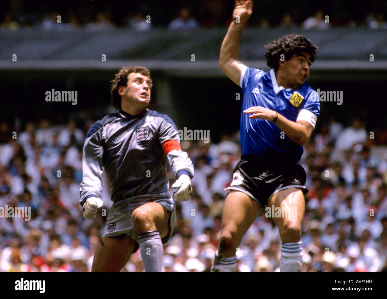 L'argentino Diego Maradona (r) vola oltre il portiere inglese Peter Shilton (l) dopo aver utilizzato il suo pugno per segnare il gol di apertura, il famigerato 'mano di Dio' gol Foto Stock