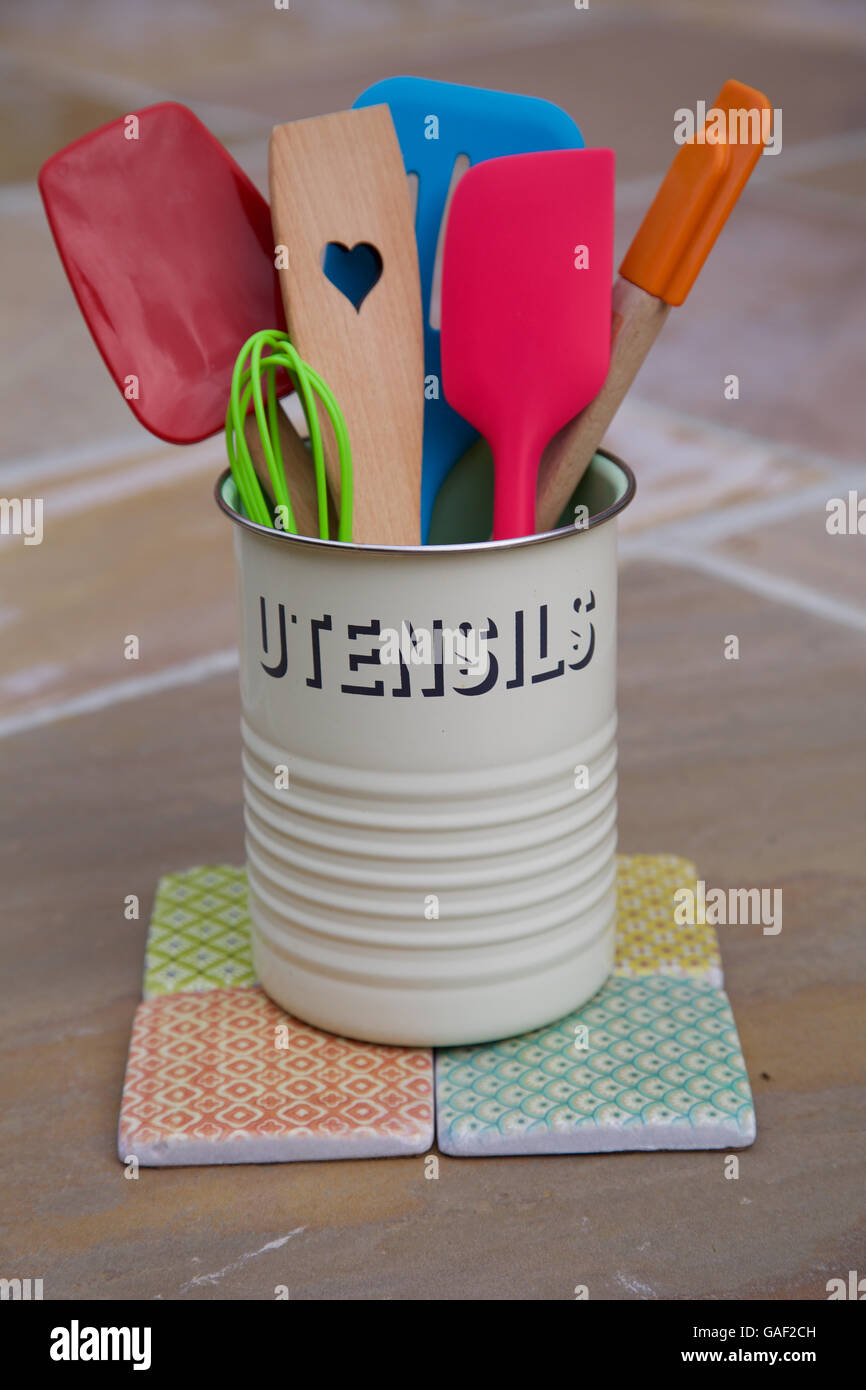 Retrò utensili da cucina pentola sul contatore di legno piastrelle sei vivaci cucina colorata spatola frusta e cucchiaio cuore l amore la cottura Foto Stock