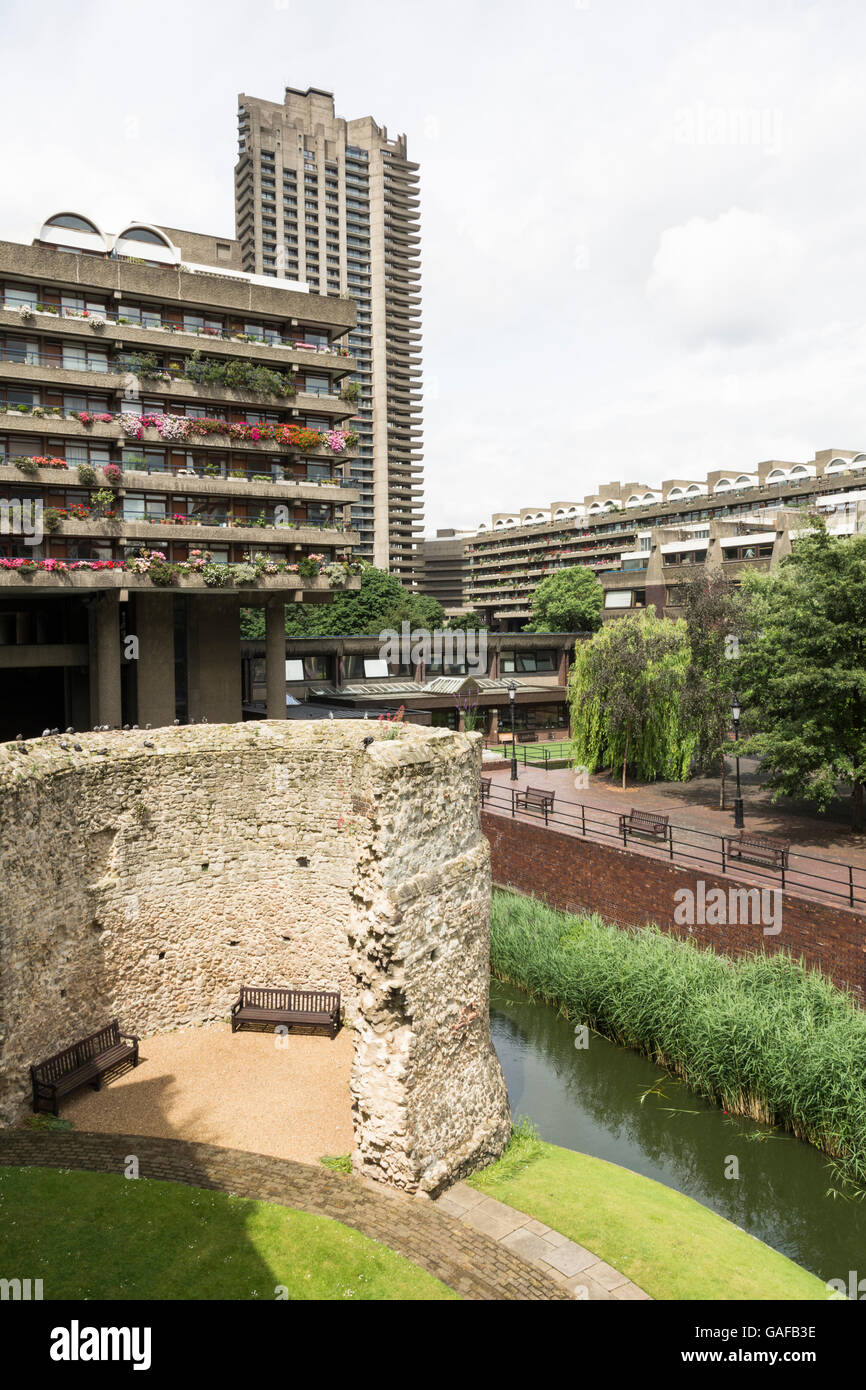 Resti del vecchio Muro di Londra, adiacente al Barbican complesso di abitazioni, nella città di Londra con San Paolo a distanza Foto Stock