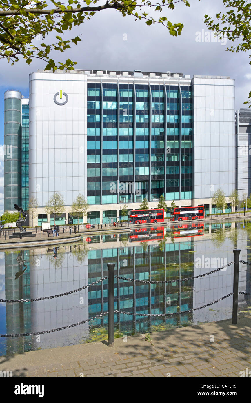 Sede del fornitore di data center Global Switch nell'East India Docks East London Inghilterra Regno Unito con autobus rossi e riflessi nell'acqua paesaggistica Foto Stock