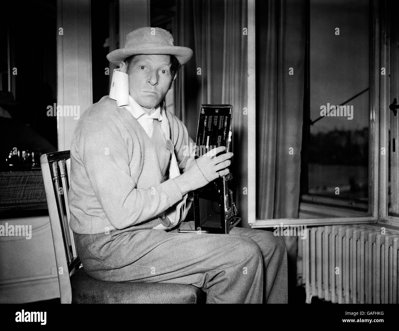 Quel grande comico americano Danny Kaye era in qualcosa di un banale quando il fotografo si recò al suo hotel di Londra per fotografarlo. In qualche modo o in altro modo, la telecamera che possiede - una telecamera Polaroid Land - si è mescolata e si è ritrovato con il rotolo di film drappeggiato intorno al collo. Foto Stock