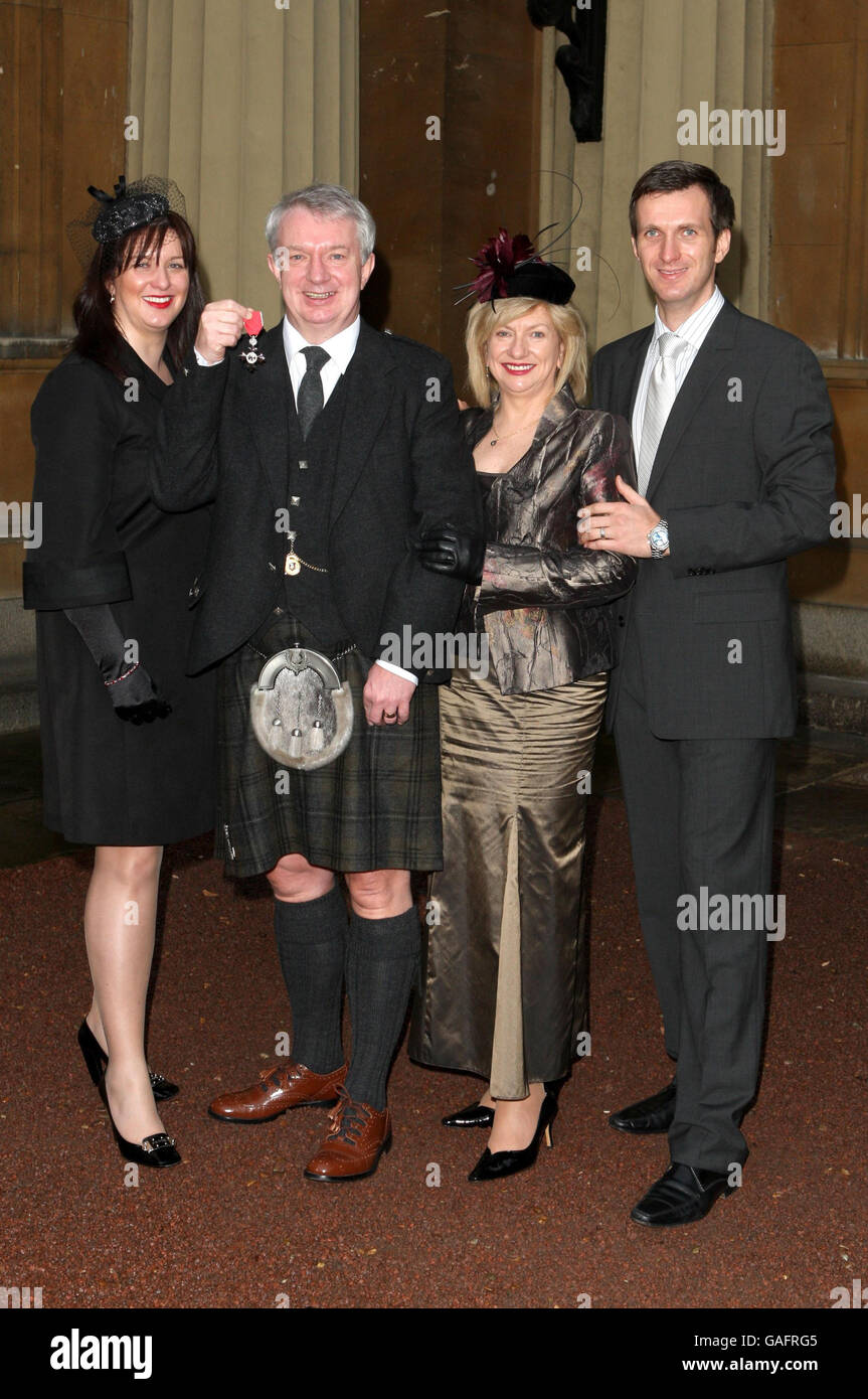 Tommy Gilmour con la figlia Stephanie Gilmour (a sinistra, sua moglie Veronica Gilmour (al centro a destra) e il figlio Christopher (a destra) mentre riceve la sua MBE a Buckingham Palace a Londra. Foto Stock