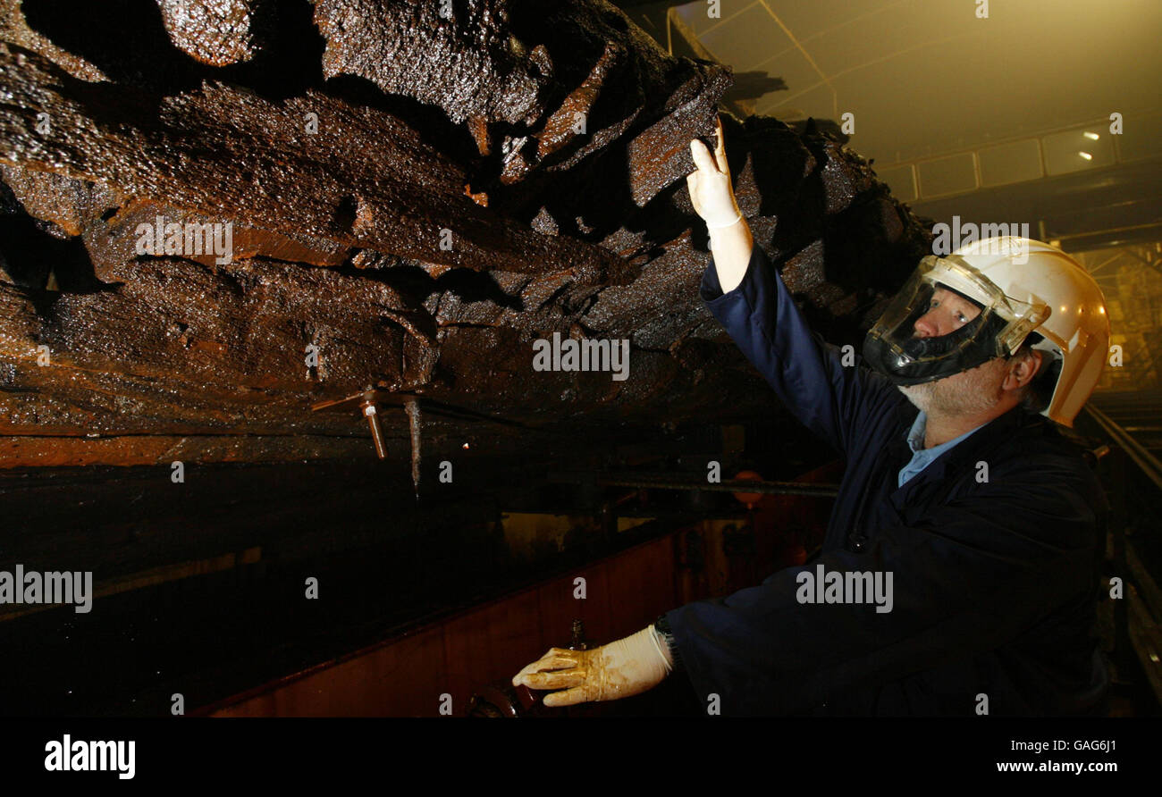 L'ingegnere della sala navale Tony Marsland ispeziona lo scafo della famosa nave da guerra di Enrico VIII, la Mary Rose, nel suo molo a secco, controllato in atmosfera, nello storico cantiere navale di Portsmouth. Foto Stock