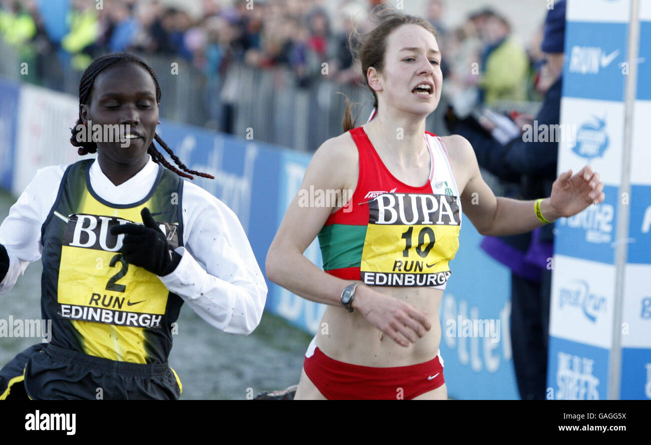 Il vian Cheruiyot del Kenya e lo Steph Twell dell'Inghilterra, attraversano la linea del 6k delle Donne, parte del BUPA Great Edinburgh International Cross Country Run nell'Holyrood Park di Edimburgo. Foto Stock