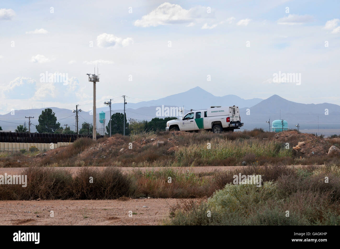 Un U.S. Pattuglia di Confine agent si siede in un veicolo alla frontiera muro con Motul, Sonora, Messico, in Douglas, Arizona, Stati Uniti. Foto Stock
