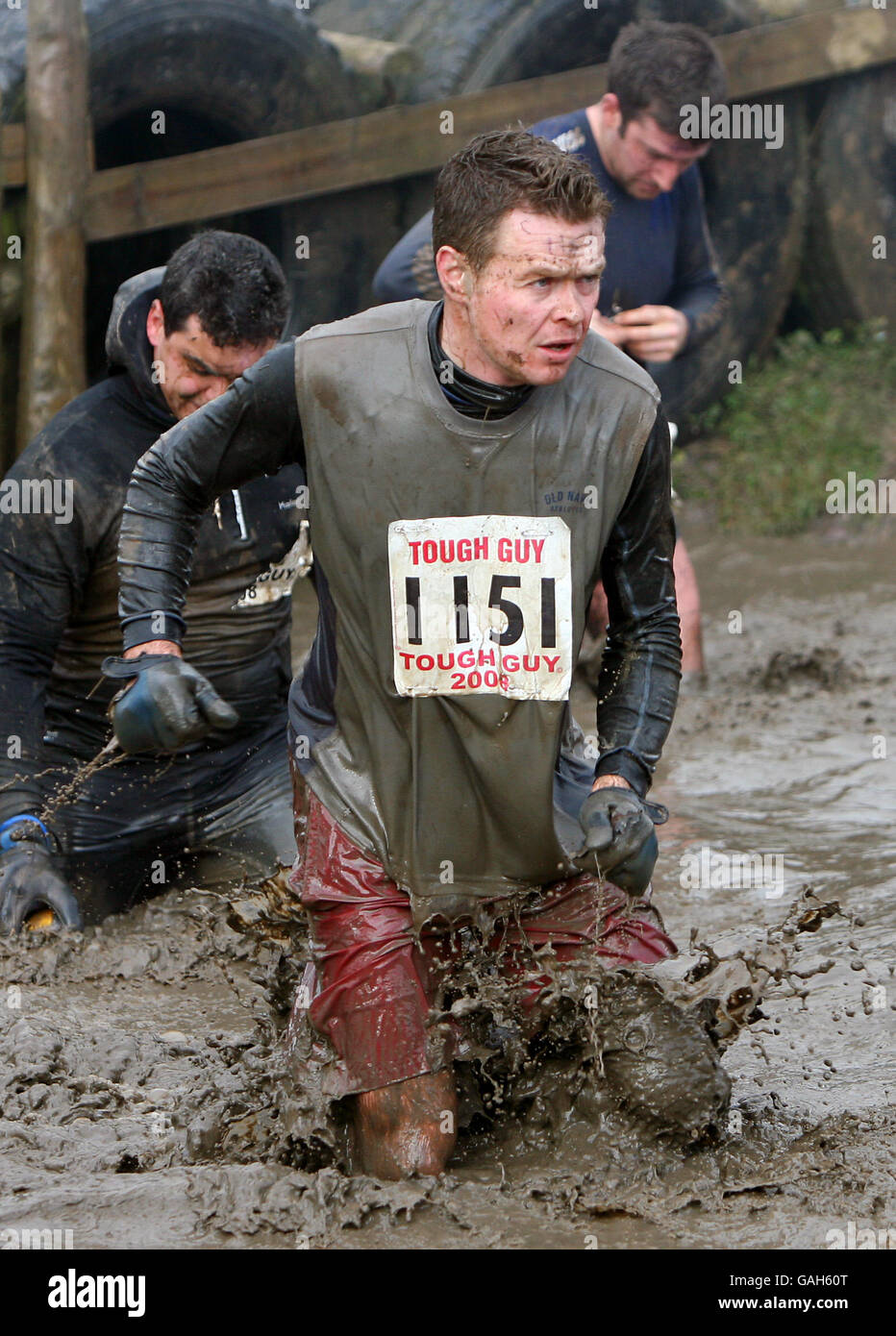 I concorrenti cadono in una grande palude come le piscine come cercano di superare vari ostacoli nel duro Guy 2008, Wolverhampton. Foto Stock