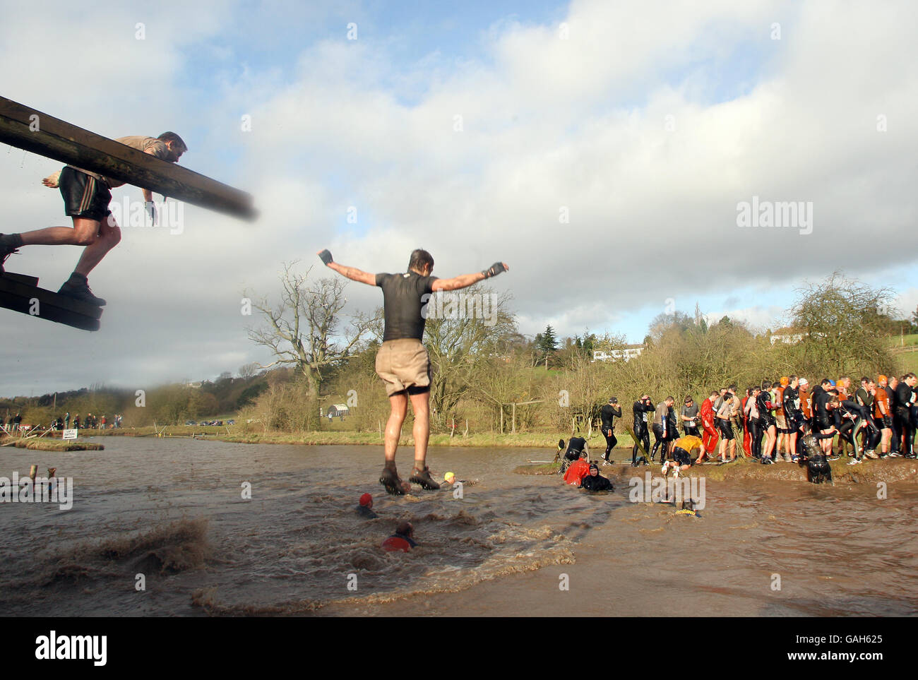 I concorrenti cadono in una grande palude come le piscine come cercano di superare vari ostacoli nel duro Guy 2008, Wolverhampton. Foto Stock