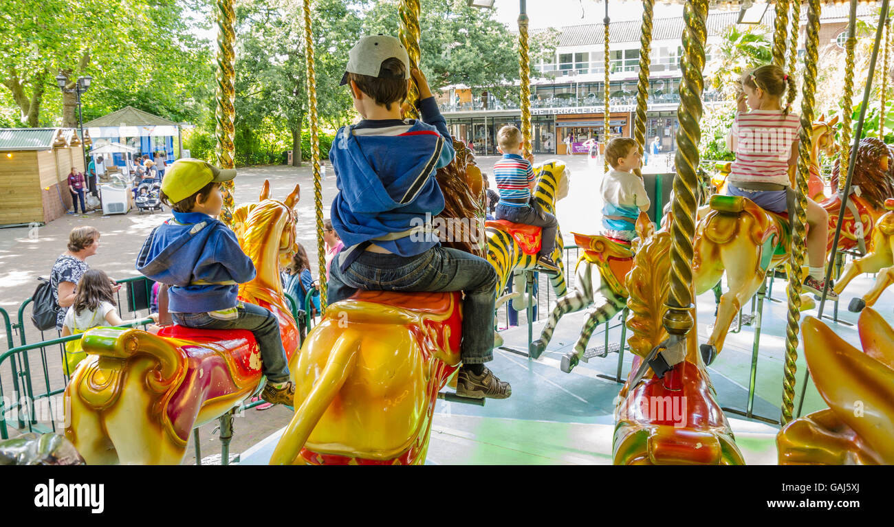 I figli piccoli di cavalcare un merry-go-round. Foto Stock