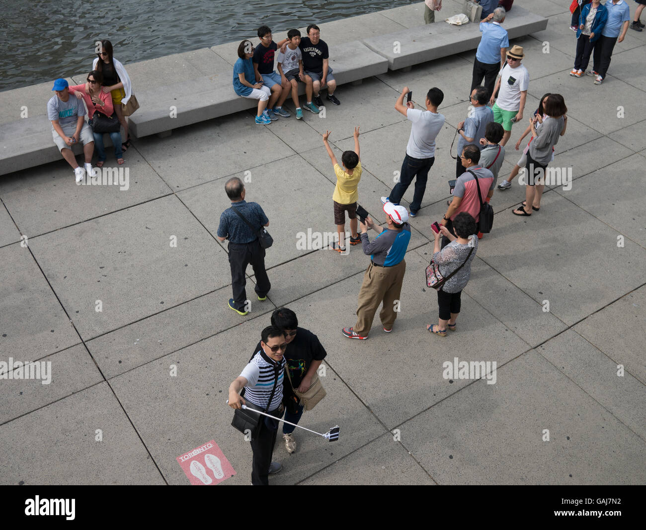 Vista aerea di turisti di scattare le foto con i telefoni intelligenti in una piazza Civica a Toronto in Canada. Foto Stock