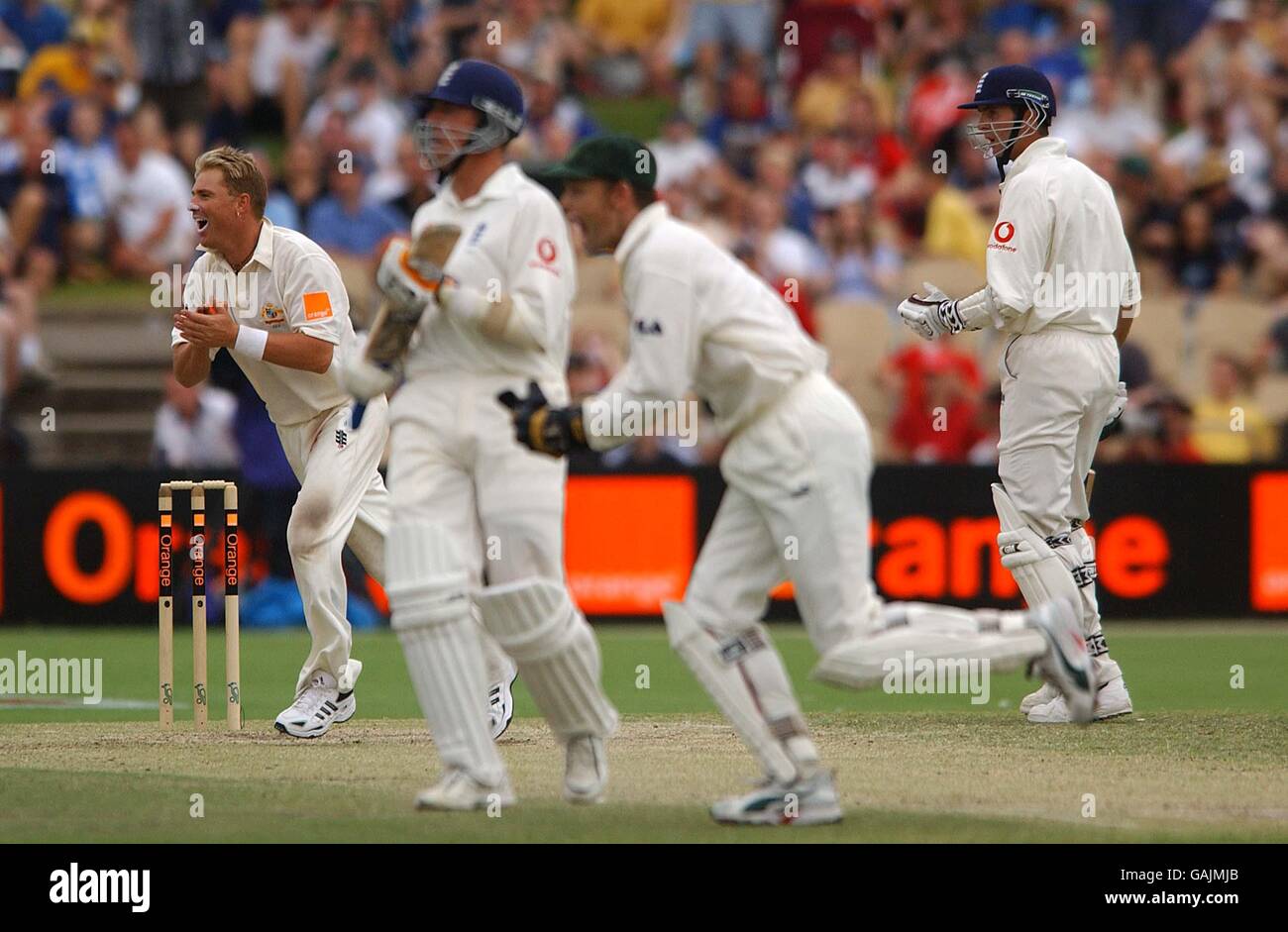 Cricket - The Ashes - seconda prova - Quarta giornata - Australia / Inghilterra. Shane Warne e Adam Gilchrist dell'Australia corrono per congratularsi con Glenn McGrath dopo aver catturato Michael Vaughan dell'Inghilterra Foto Stock