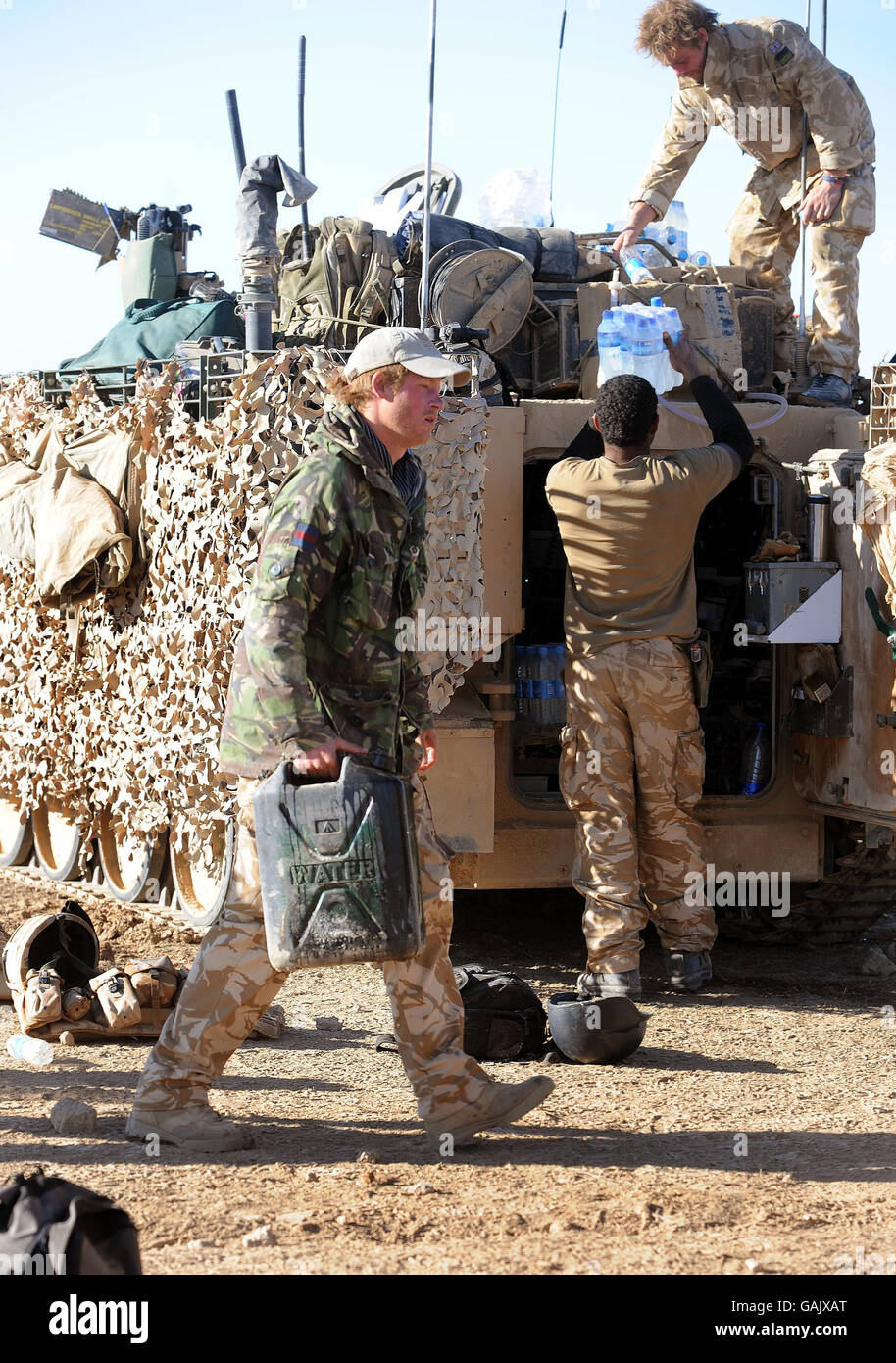 Il principe Harry trasporta una lattina d'acqua al suo corriere del personale armata Spartan nel deserto nella provincia di Helmand nell'Afghanistan meridionale. Foto Stock