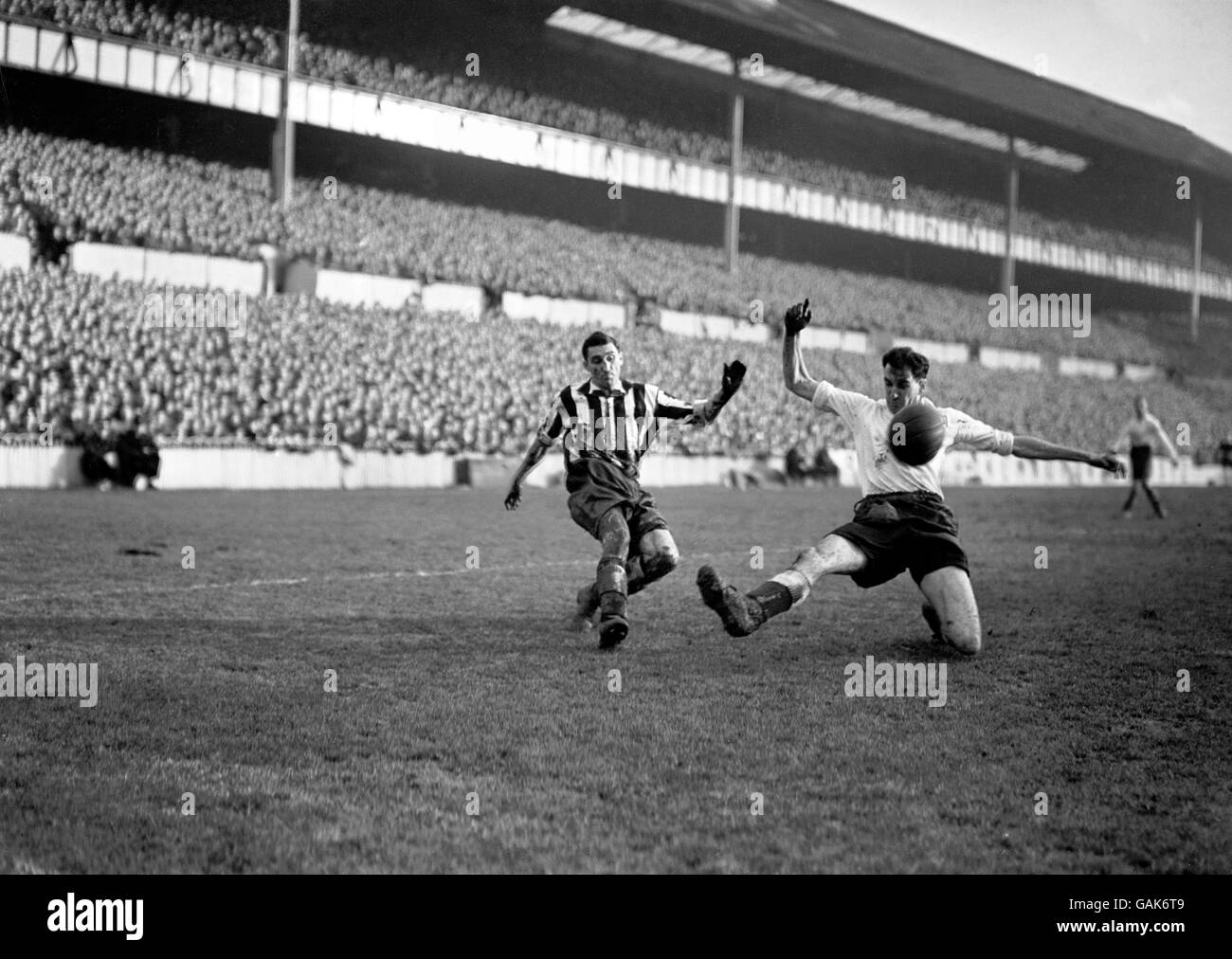(L-R) Tommy Walker di Newcastle United attraversa la palla oltre il Gamba allungata di Harold Clarke di Tottenham Hotspur Foto Stock