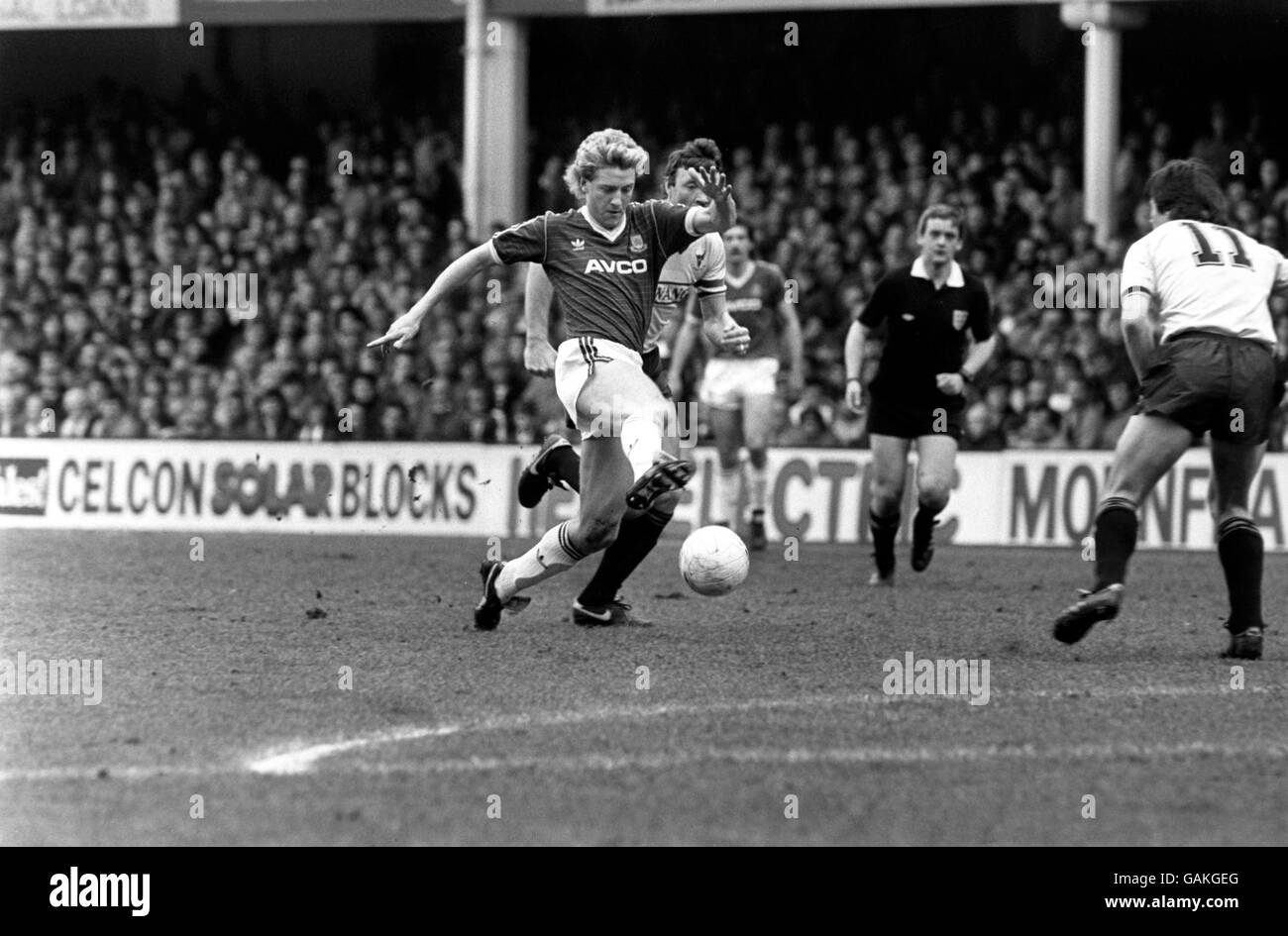 (L-R) Frank McAvennie di West Ham United porta la palla giù Come lo persegue Malcolm Shotton di Oxford United Foto Stock