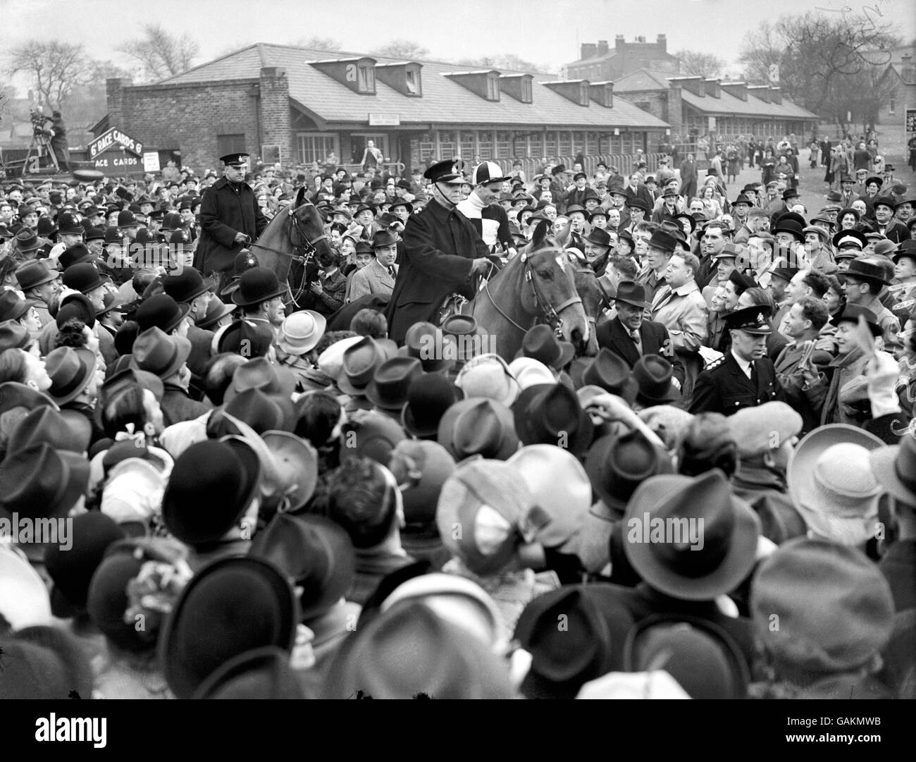 L'eroe russo, Leo McMorrow in su, è guidato attraverso la folla enorme a Aintree dopo aver vinto il National Foto Stock