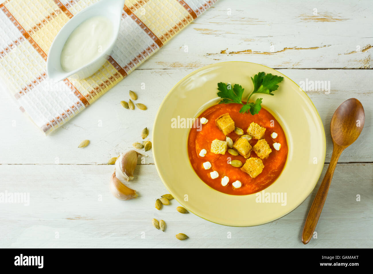 Crema di zucca zucca minestra di verdura con crema, semi di zucca, crostini di aglio e prezzemolo in una luce gialla piastra, vista dall'alto Foto Stock