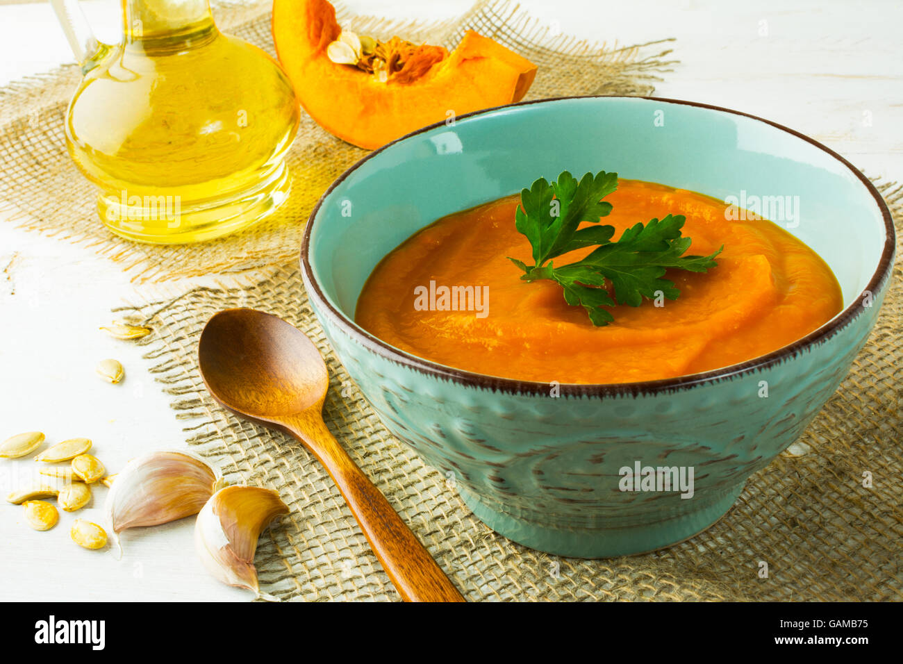 Arrosto di crema di zucca zuppa con il prezzemolo in turchese cup su tela, close up Foto Stock