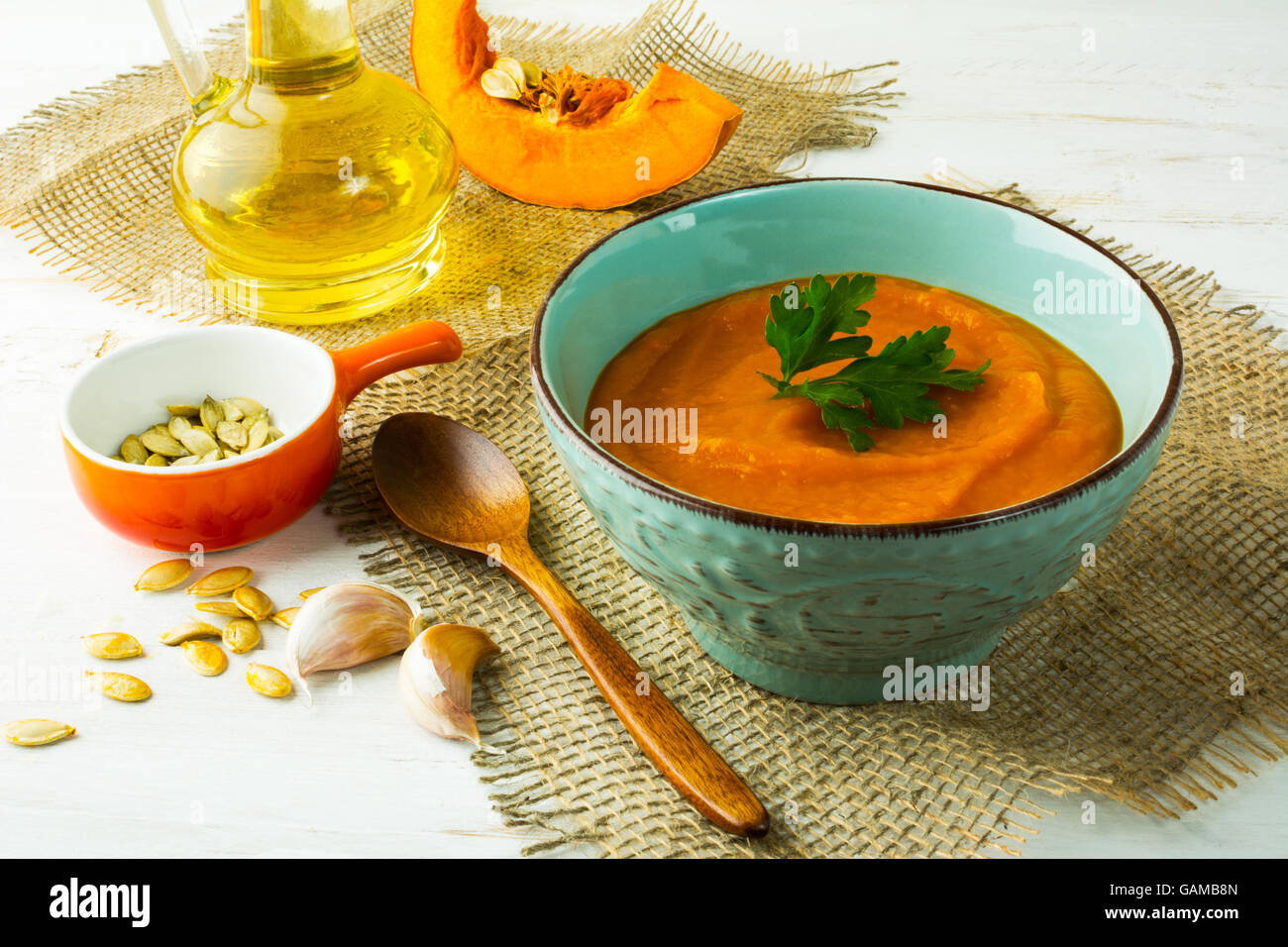 Speziato arrosto di crema di zucca zuppa con il prezzemolo in turchese cup su tela Foto Stock