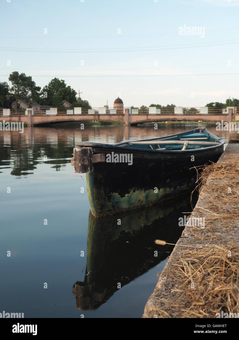 L'acqua,ponte, riflessioni e barca vuota su bayou St John, New Orleans, Louisiana Foto Stock