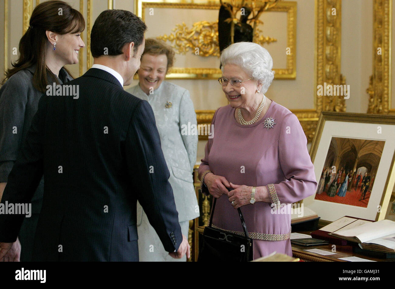 Il presidente francese Nicolas Sarkozy, e sua moglie Carla Bruni-Sarkozy parlano con la regina Elisabetta II della Gran Bretagna, in quanto vengono mostrati oggetti della Royal Collection al Castello di Windsor. Foto Stock