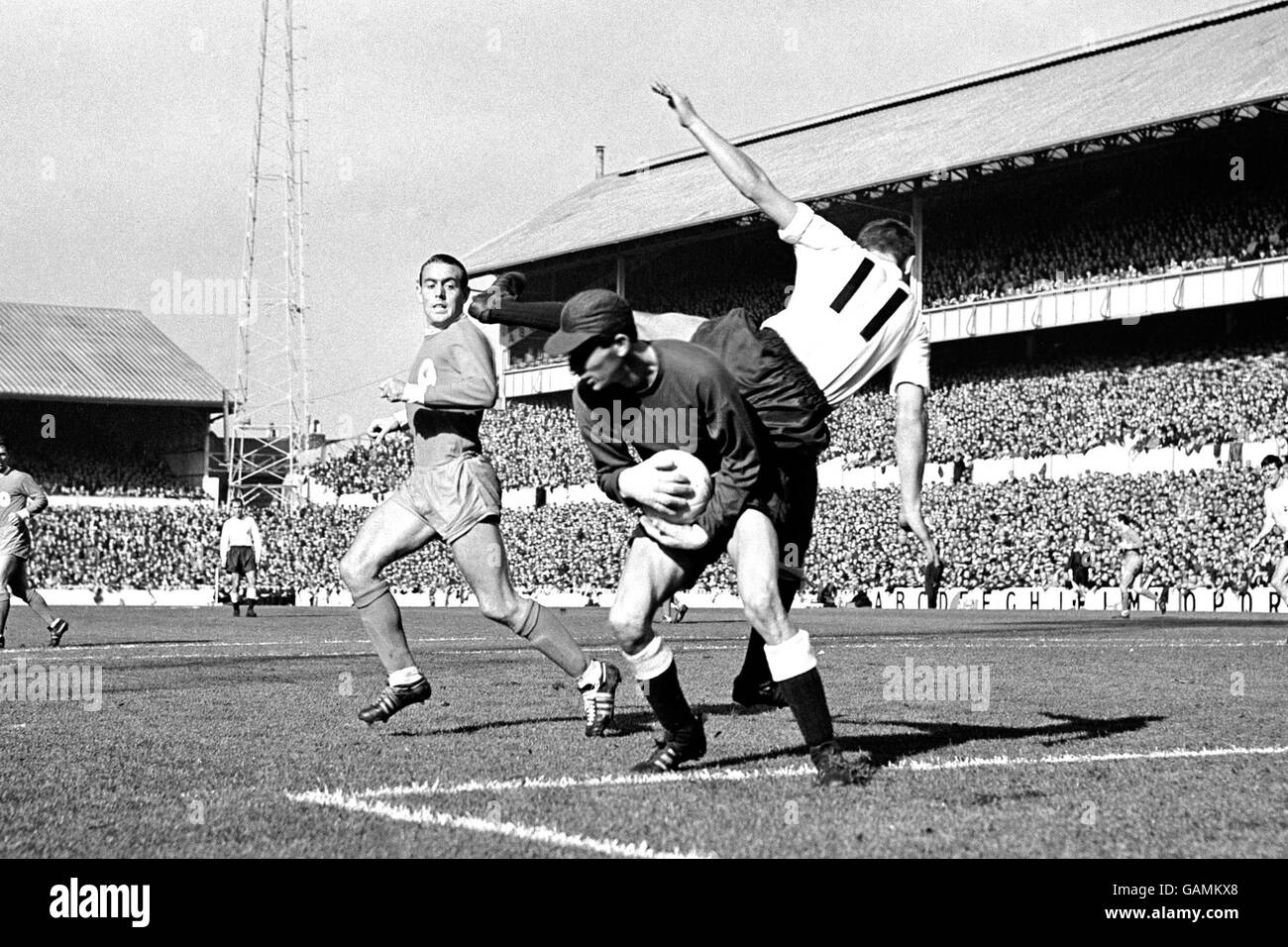 (L-R) Ian St John di Liverpool guarda come Bill Brown, portiere di Tottenham Hotspur, raccoglie la palla sotto pressione dal suo compagno di squadra Keith Weller Foto Stock