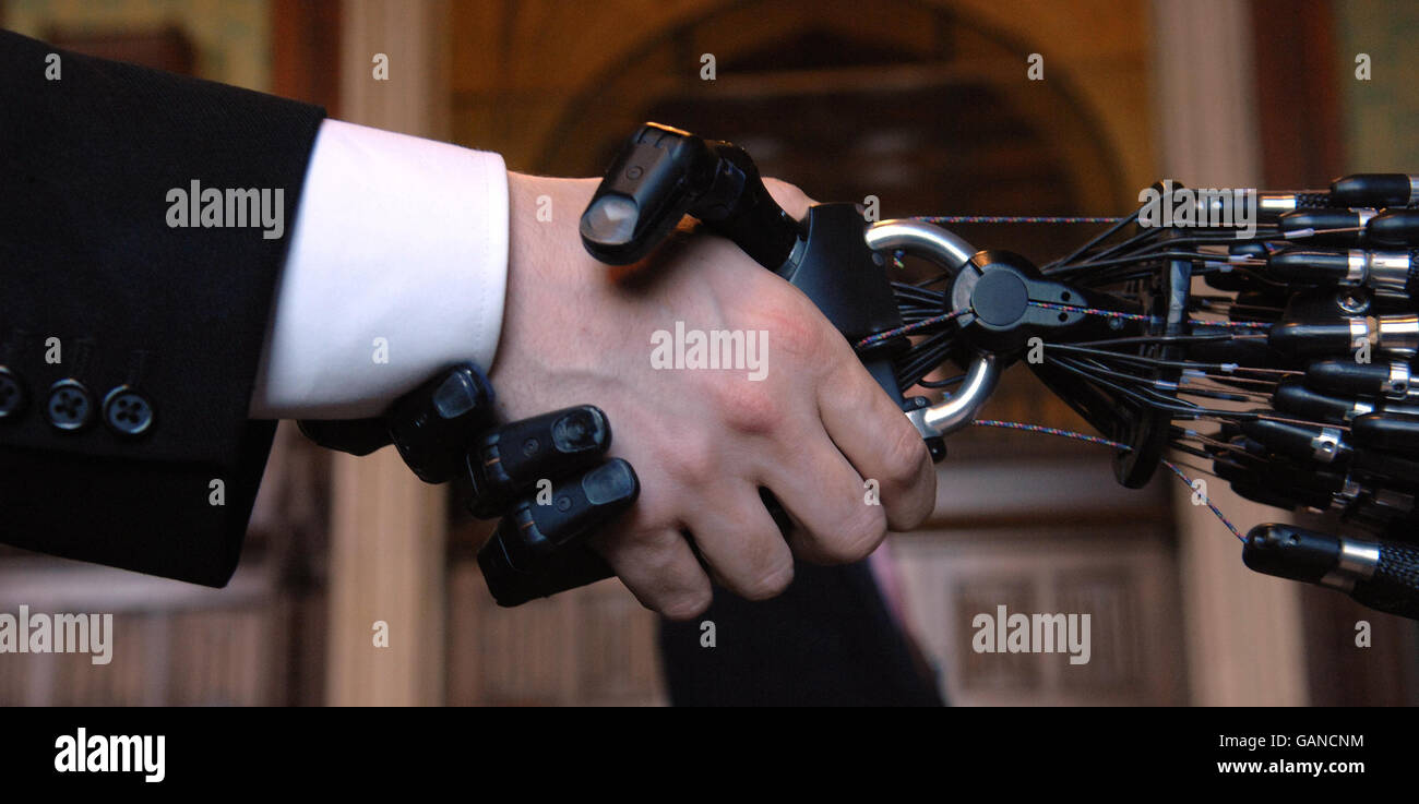 Una persona scuote le mani nella Camera dei Comuni, Londra, con la mano di destrous C5 della Shadow Robot Company. L'unica mano di robot al mondo capace degli stessi movimenti della mano umana, sviluppata per applicazioni industriali. Foto Stock