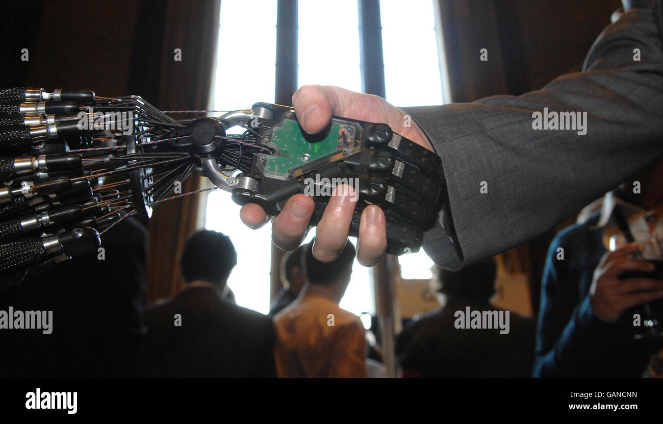 Una persona scuote le mani nella House of Commons, Londra, con la mano destrous C5 di Shadow Robot Company, l'unica mano robotica al mondo in grado di compiere gli stessi movimenti della mano umana, sviluppata per applicazioni industriali. Foto Stock